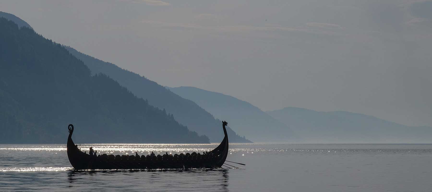 About The Viking Dragon - Background Image of Longship on a Fjord