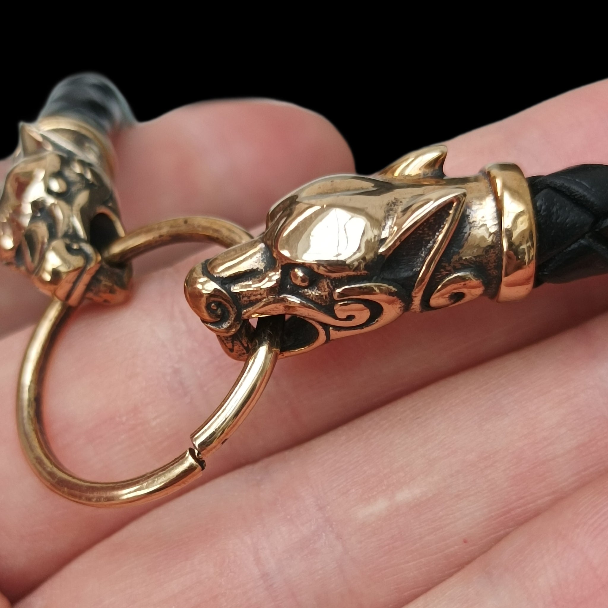 8mm Width Braided Leather Necklace with Bronze Ferocious Wolf Heads and Split Ring on Hand - Close Up Side View