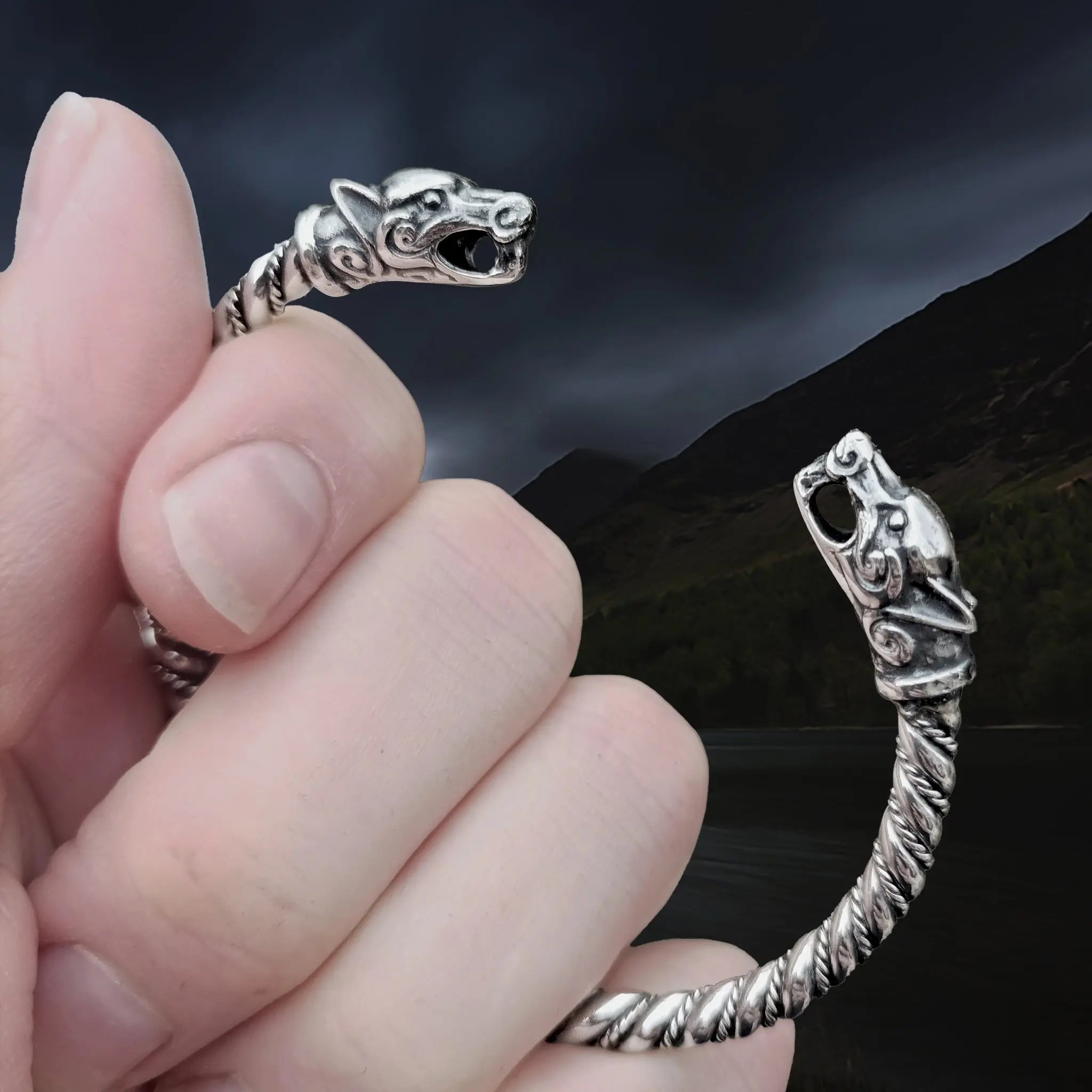 Twisted Silver Viking Bracelet With Ferocious Wolf Heads in hand - Closer View