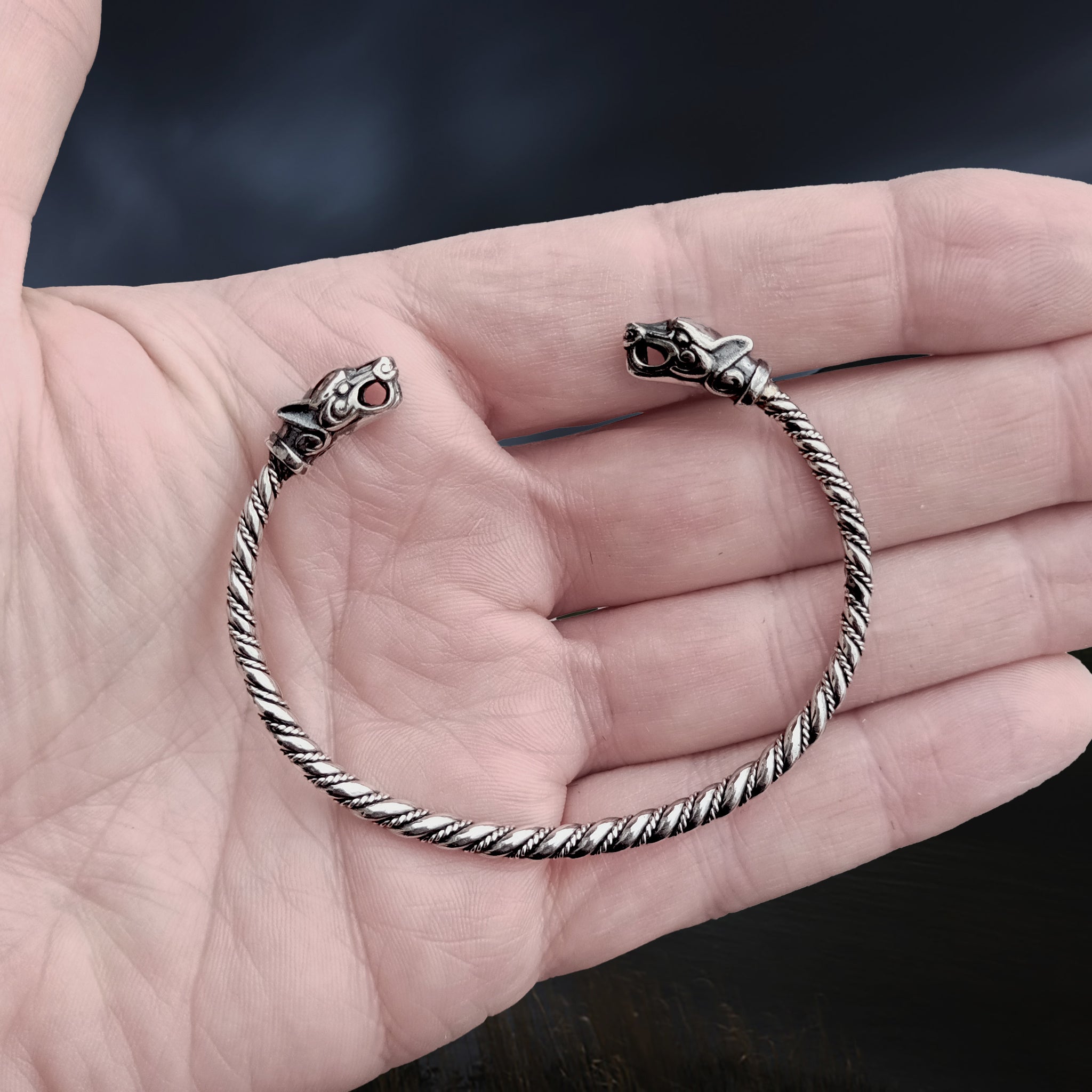 Slim Twisted Silver Viking Bracelet With Ferocious Wolf Heads on Hand