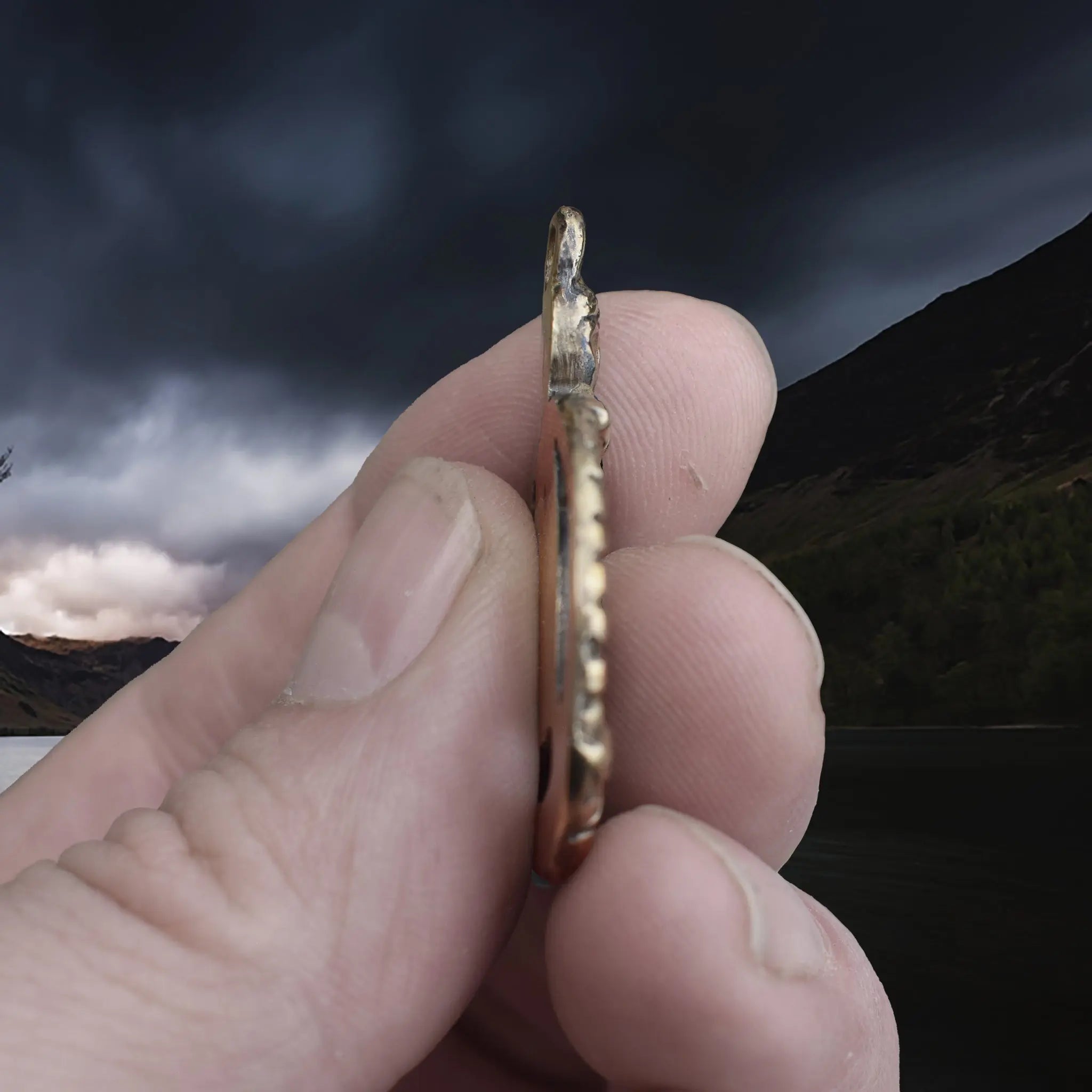Large Bronze Circular Freya Pendant Replica with Top Loop in Fingers - Side View
