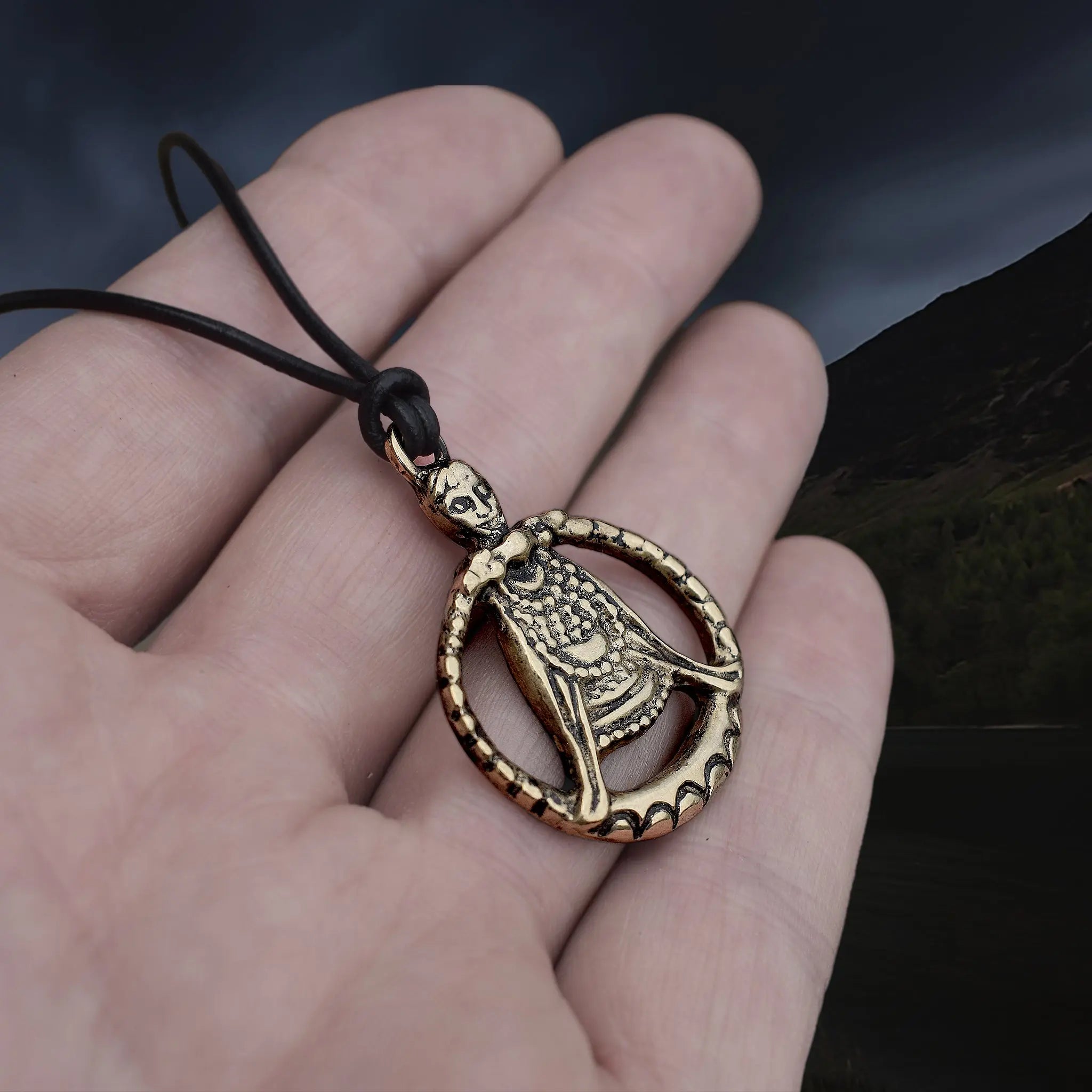 Large Bronze Circular Freya Pendant Replica with Top Loop on Leather Cord, on Hand - Side Angle View