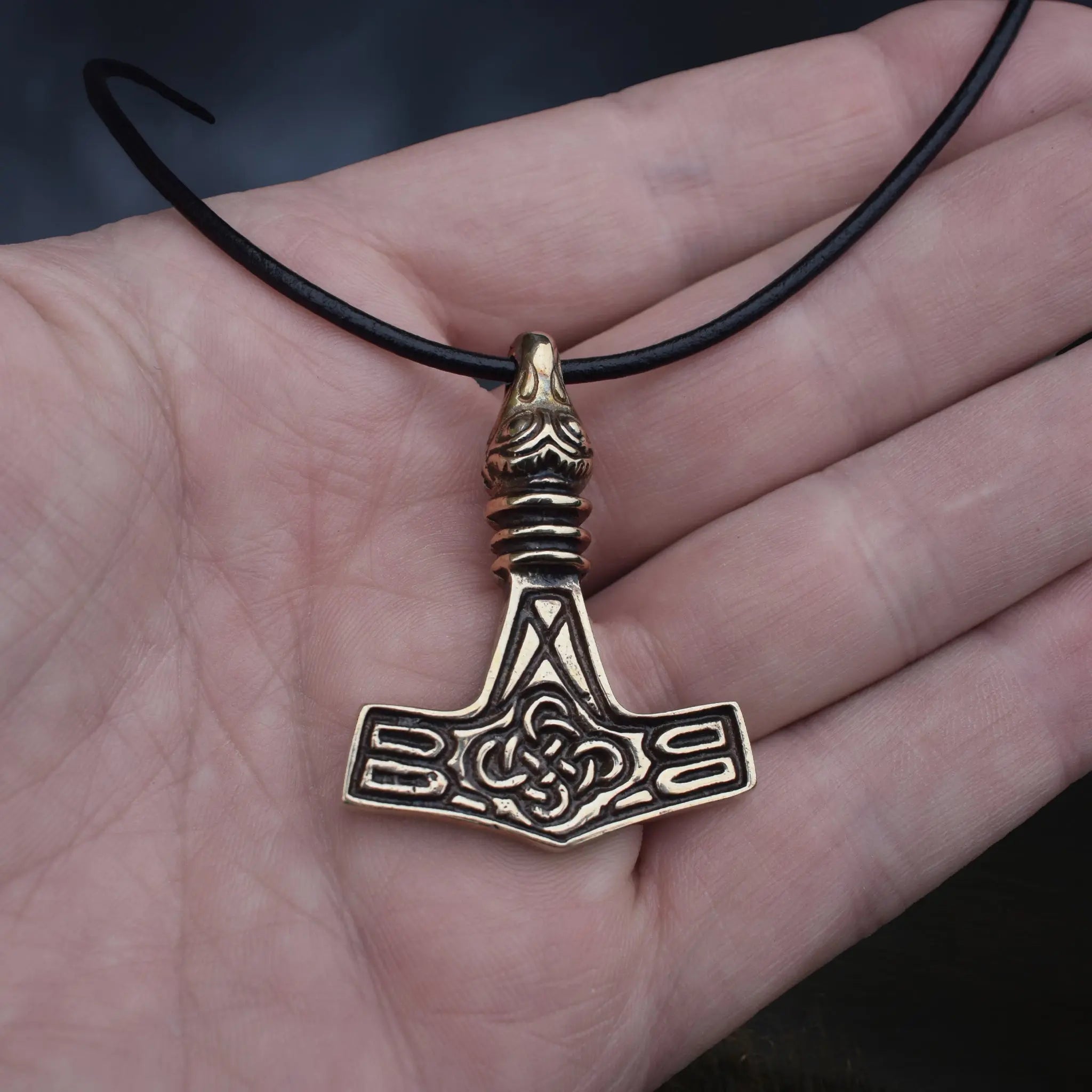 Replica Bronze Viking Age Thor's Hammer Pendant from Sweden with Raven Head on Leather Cord, on Hand