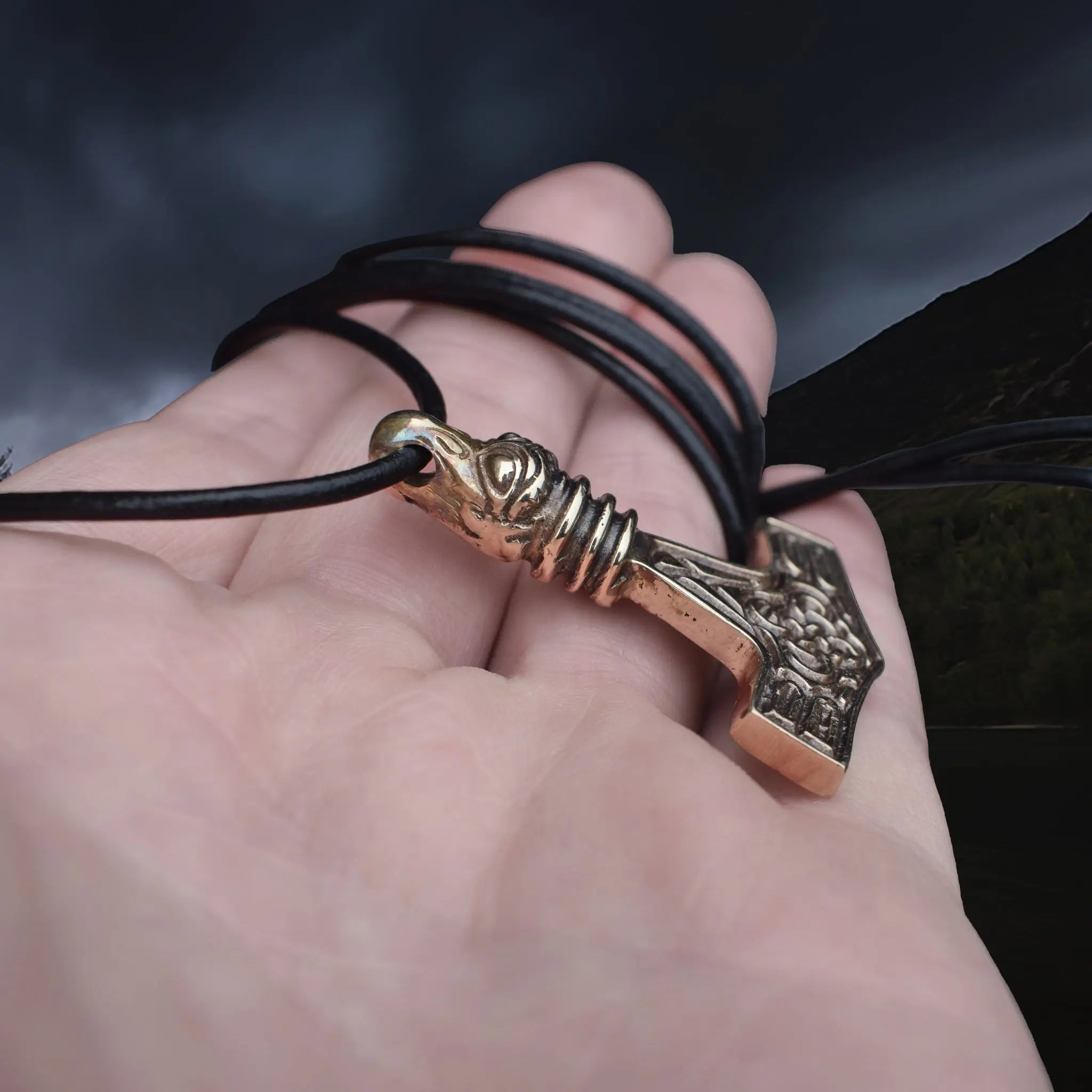 Replica Bronze Viking Age Thor's Hammer Pendant from Sweden with Raven Head on Leather Cord, On Hand - Side Angle View