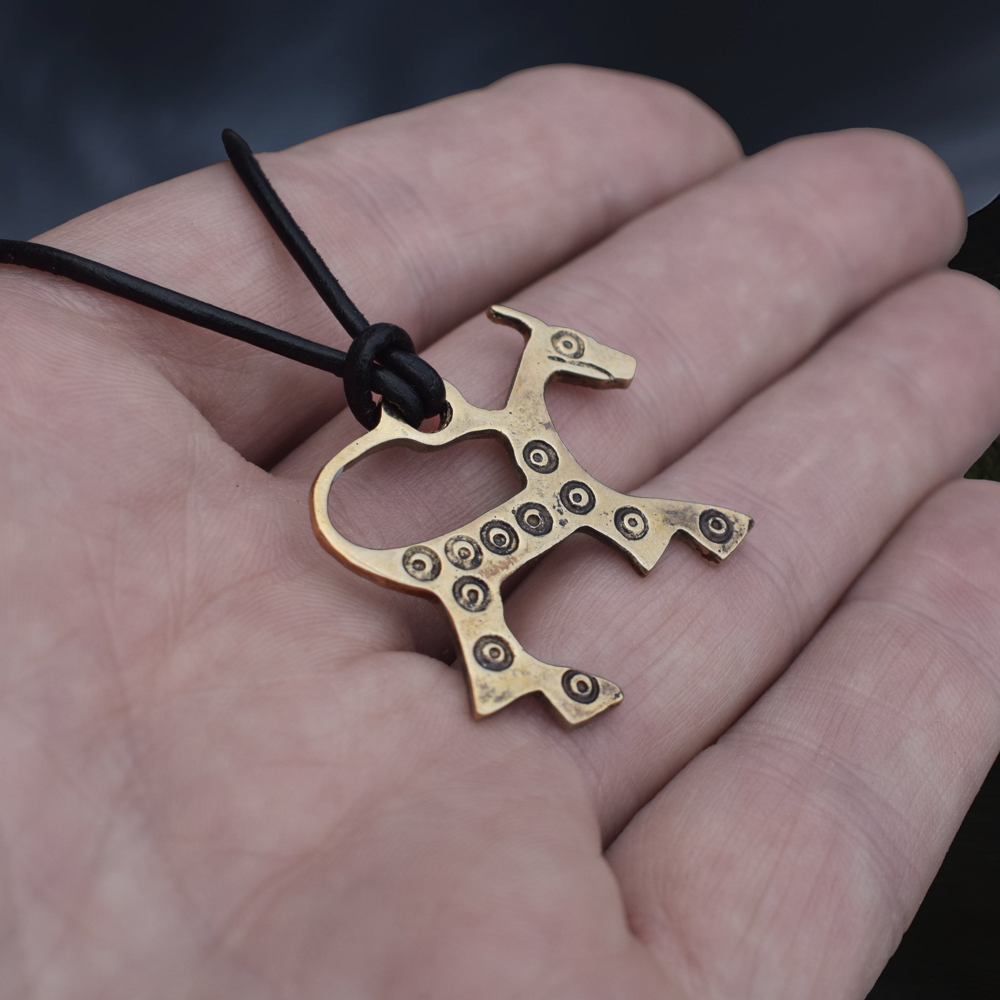 Bronze Replica Viking Horse Pendant from Novgorod on Leather Cord, on Hand - Side Angle View