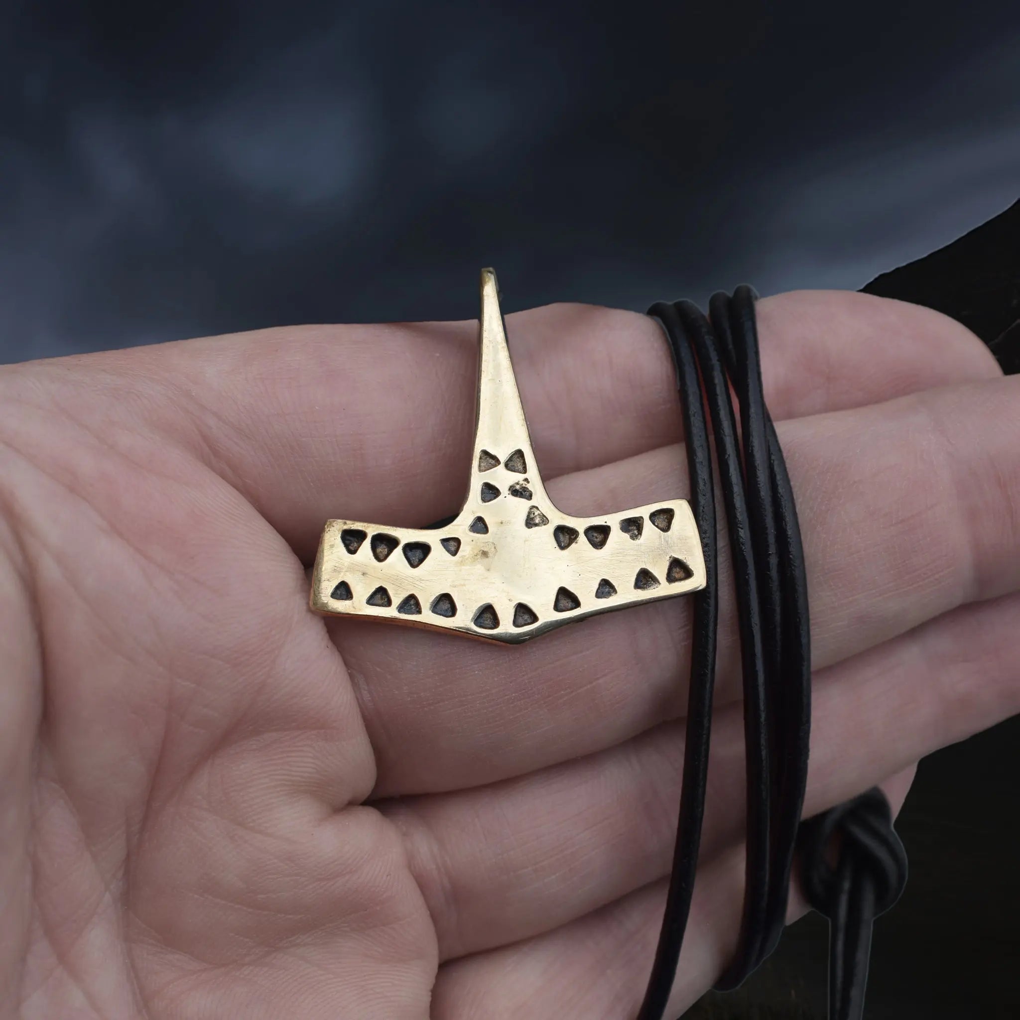 Bronze Viking Thor's Hammer Pendant Replica from 10th Century Denmark with Triangle Patterns on Leather Cord, Wrapped Around Hand