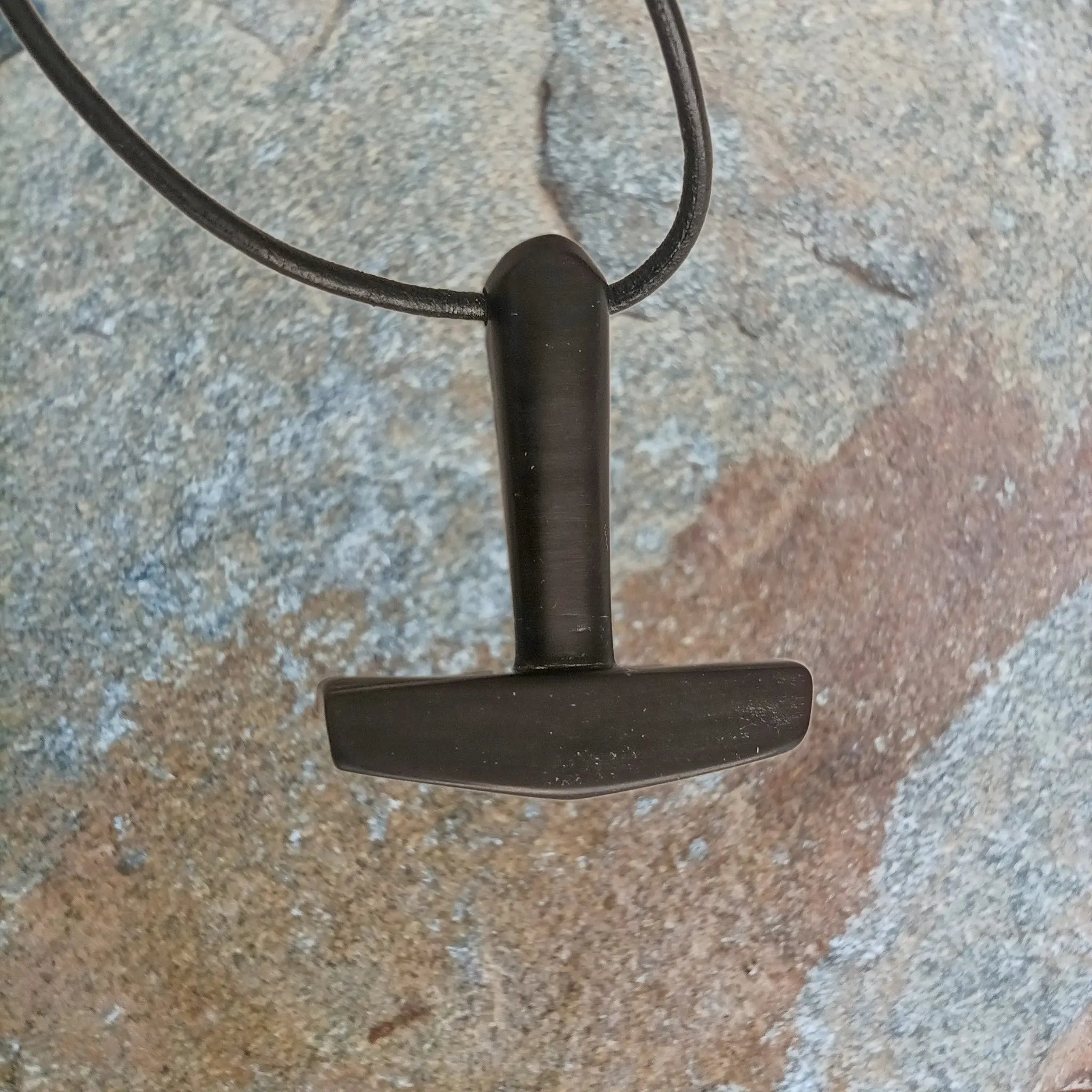 Large Black Horn Thors Hammer Pendant on Leather Cord on Rock