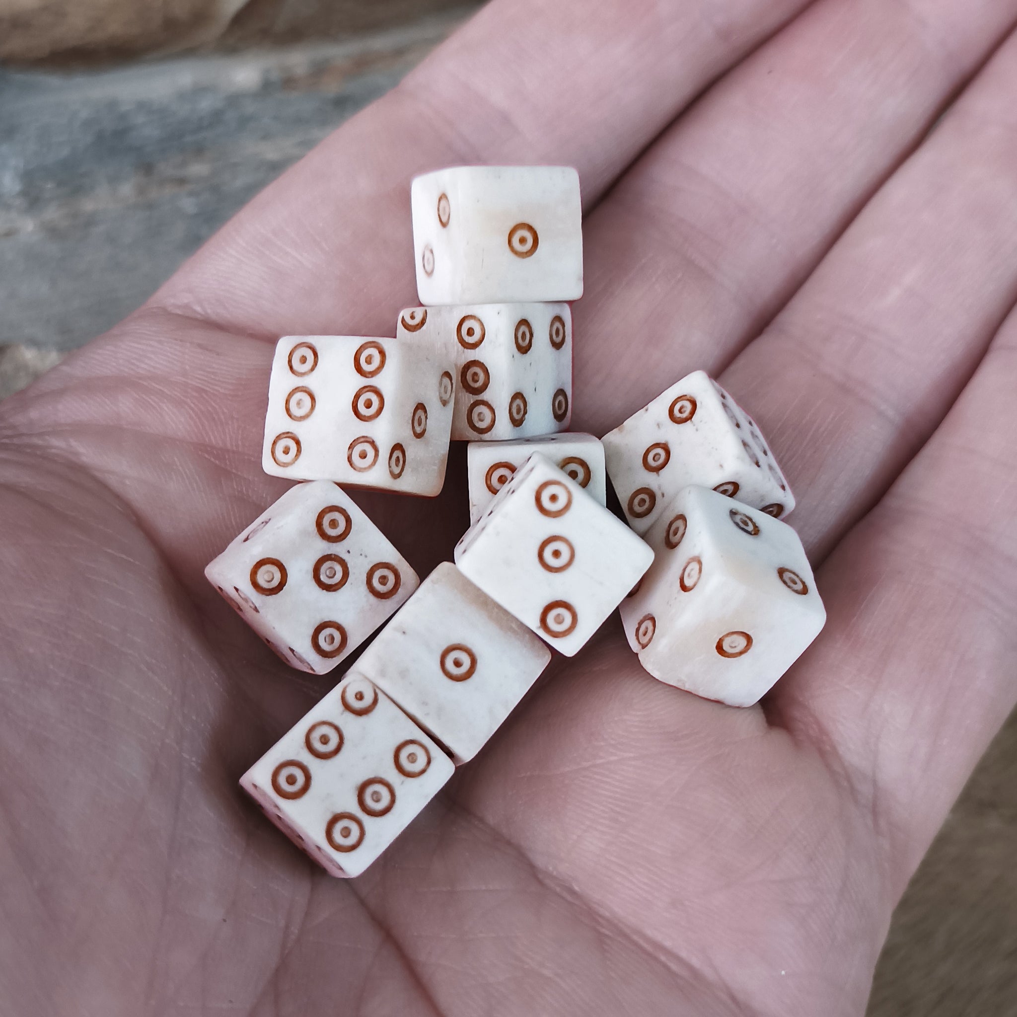 Medium Bone Dice With Brown Dot and Rings Marks on Hand