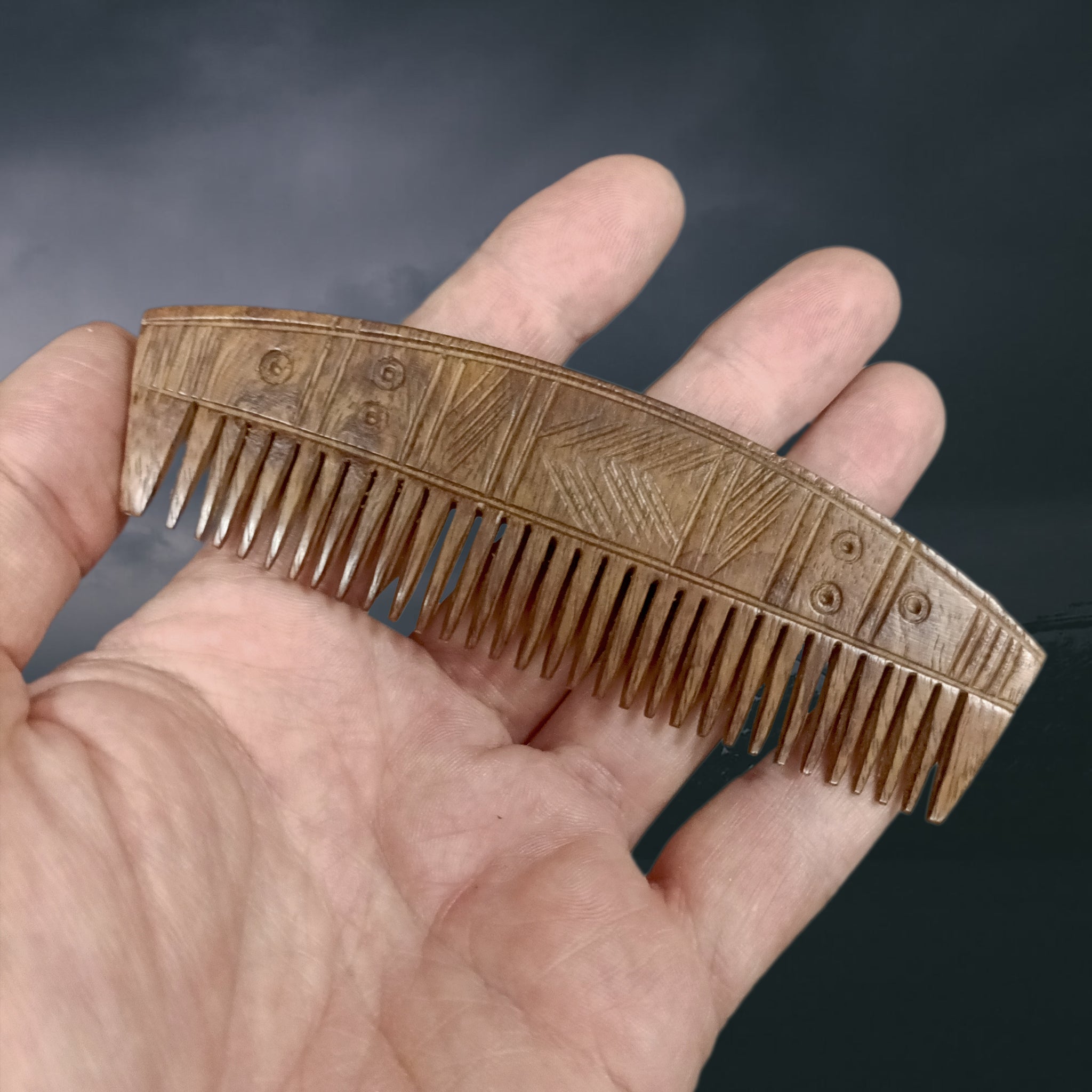 Decorated Wood Viking Comb with Curved Back on Hand