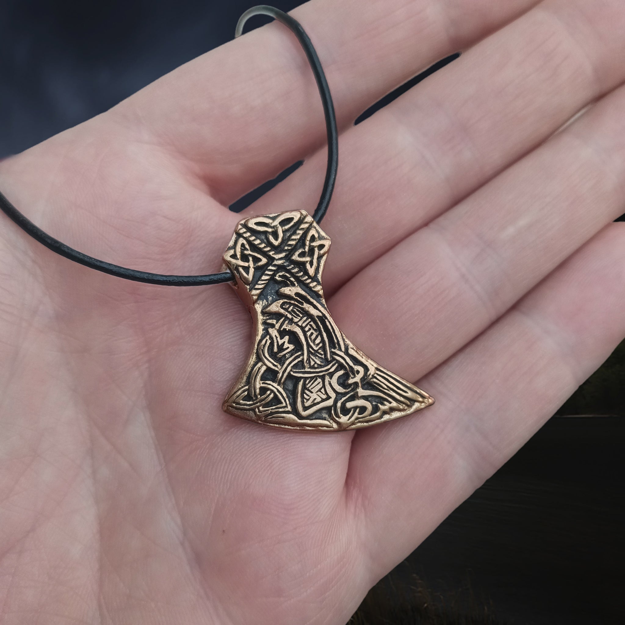 Bronze Knotwork Axe Head Pendant on Leather Thong on hand