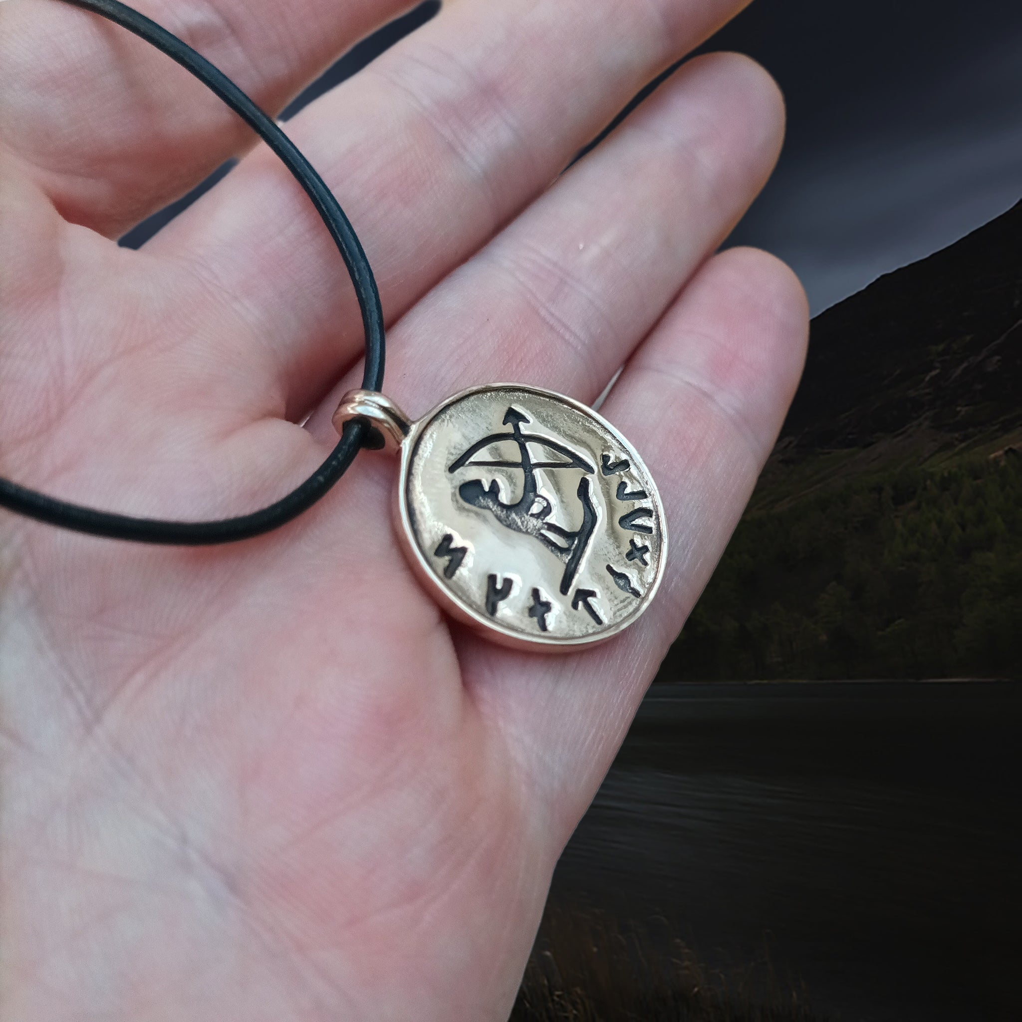 Bronze Skadi Ull Viking Pendant on Leather Thong on Hand - Angle View