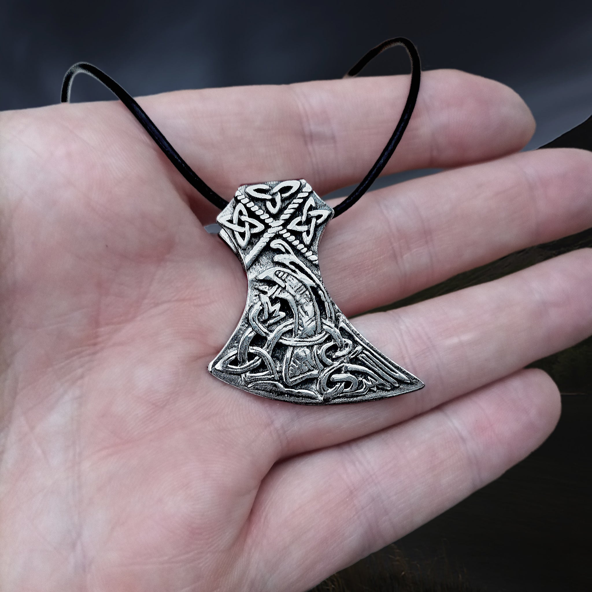 Silver Knotwork Viking Axe Head Pendant on Hand with Leather Thong