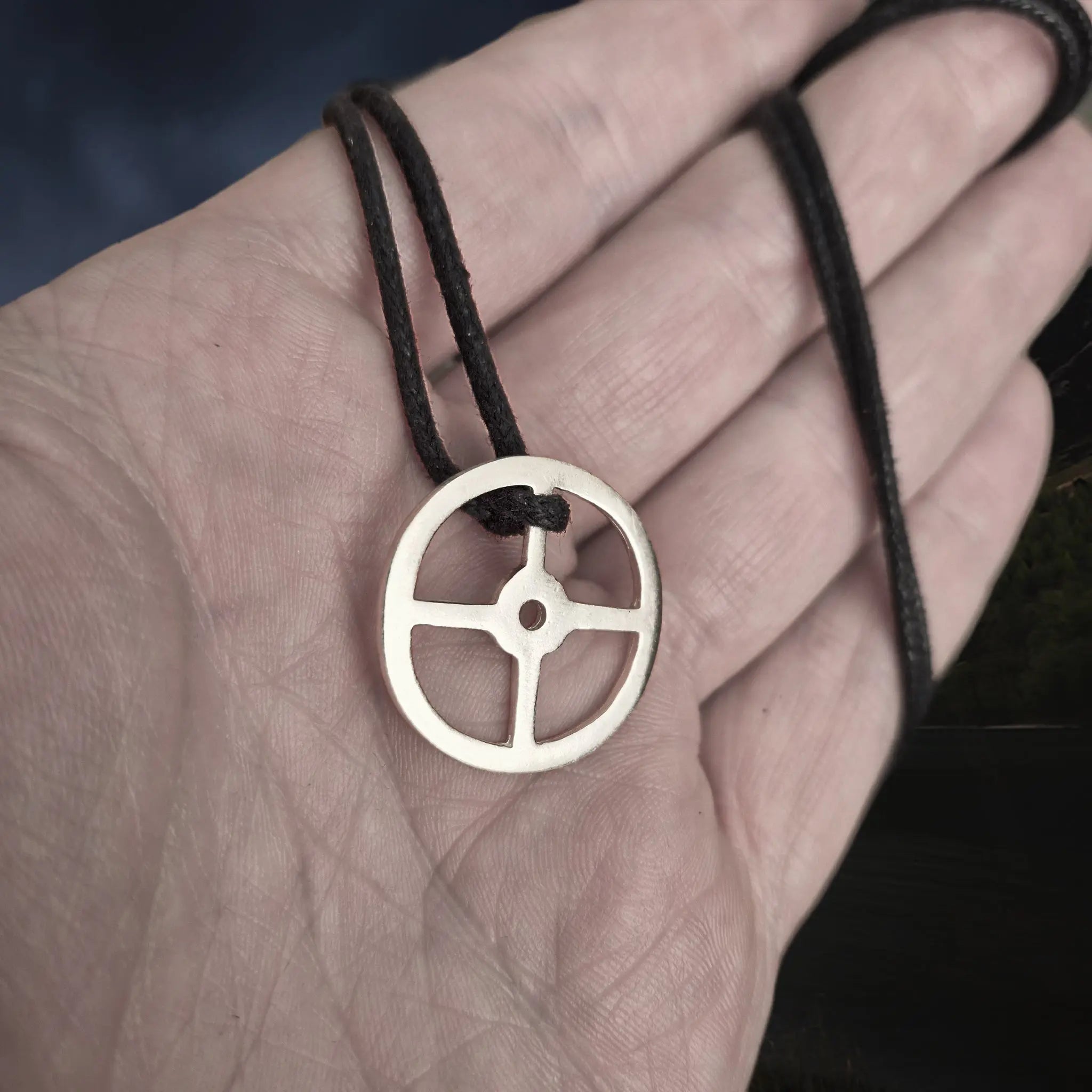 Handmade Replica Viking Sun Cross Odin Pendant in Sterling Silver on Black Linen Cord, on Hand - Slight Angle View