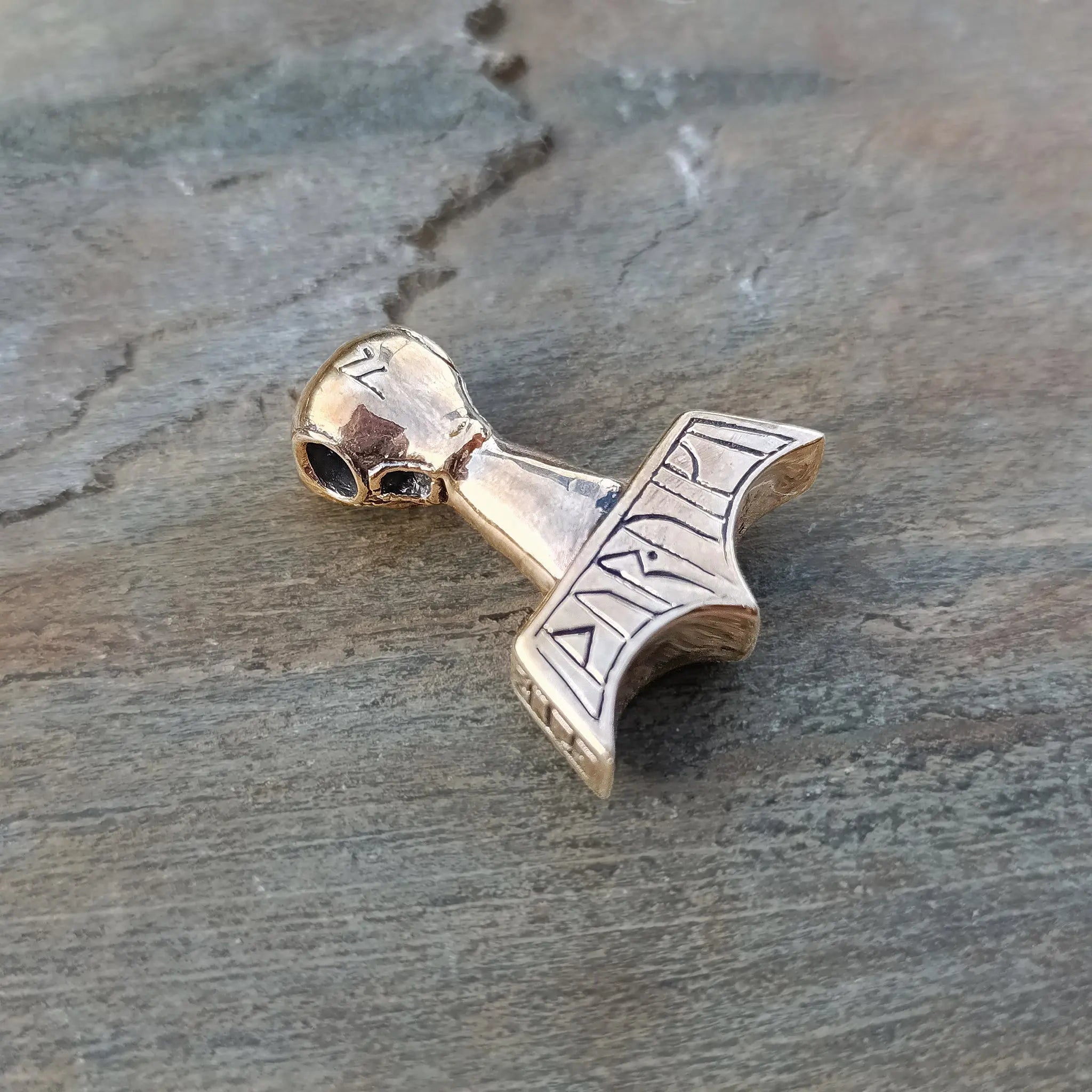 Bronze Ferocious Beast Thors Hammer Pendant on Rock - Back Angle View