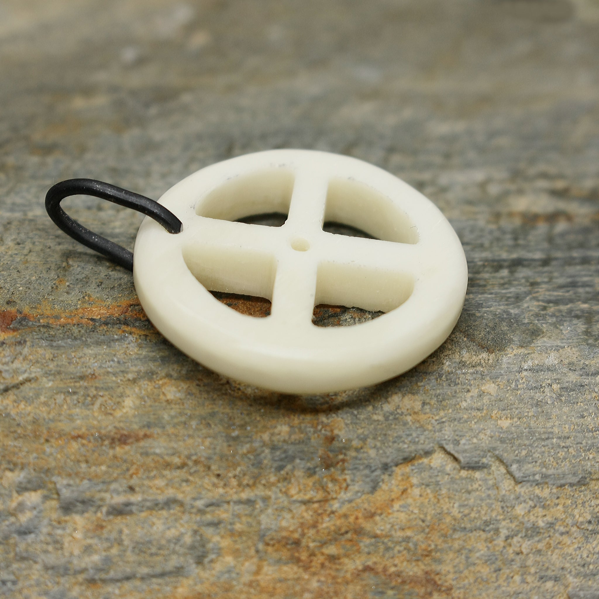 Bone Sun Cross Odin Pendant on Rock - Side View