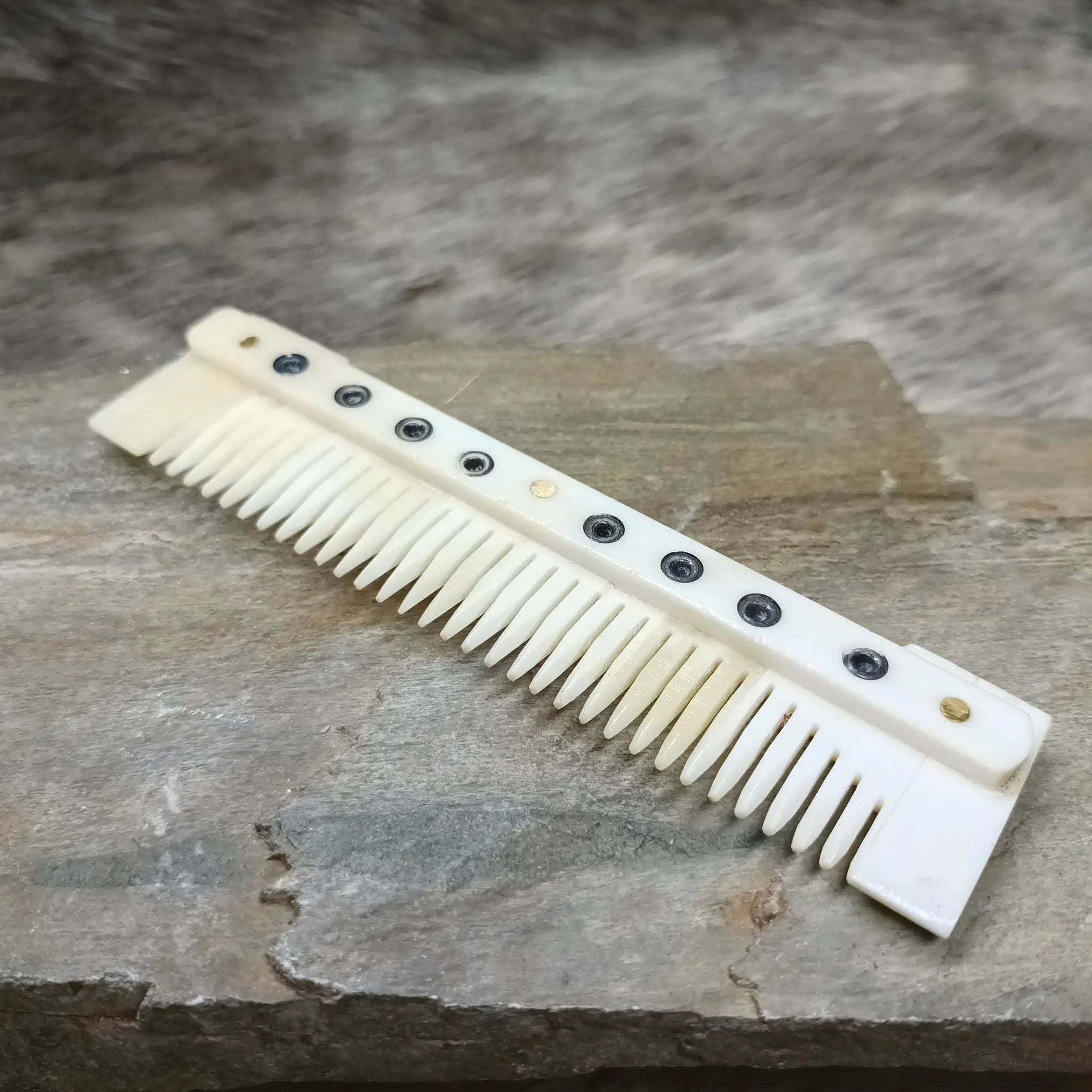 Medium Decorated Bone Viking Comb on Rock - Angled View