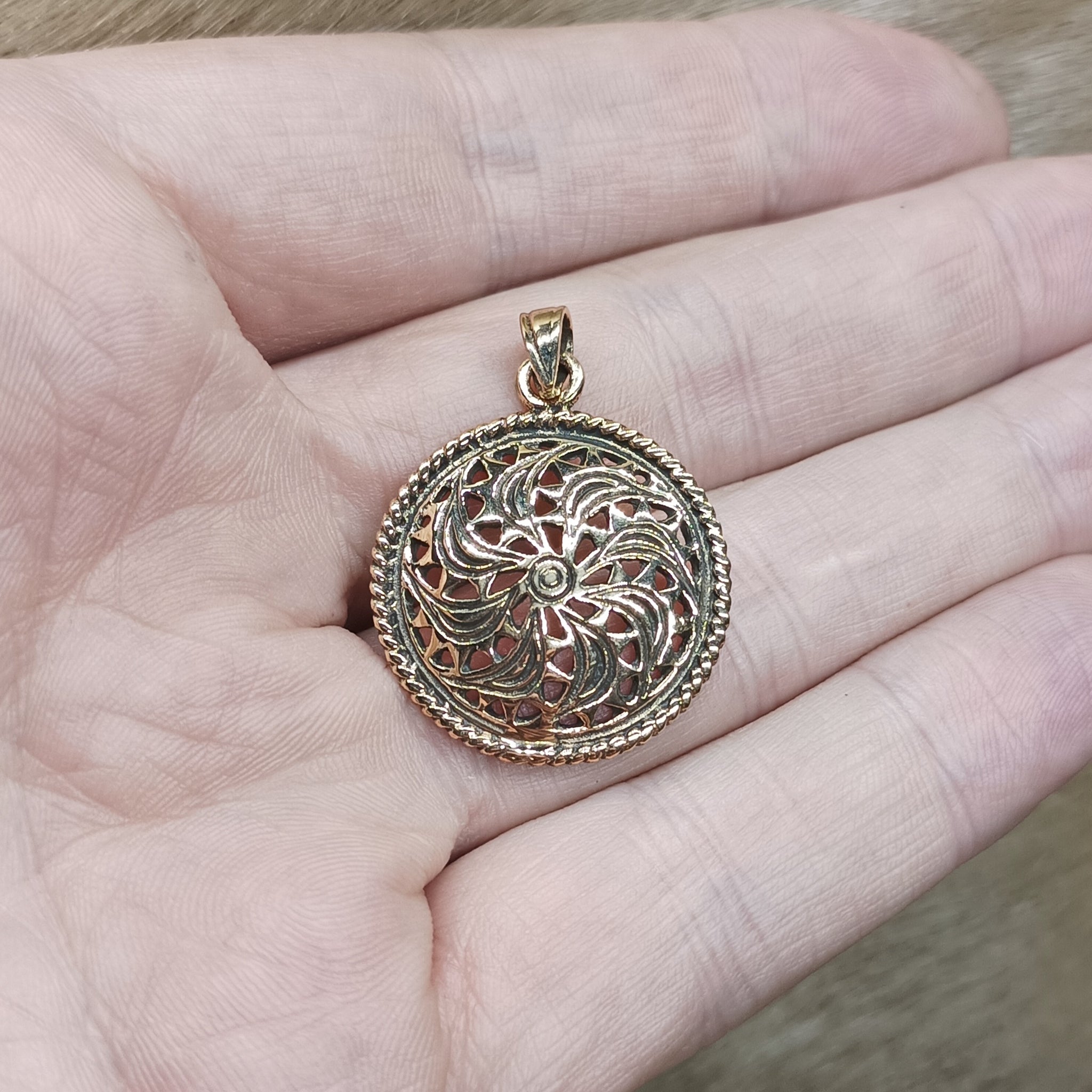 Bronze Sun Wheel Pendant on Hand