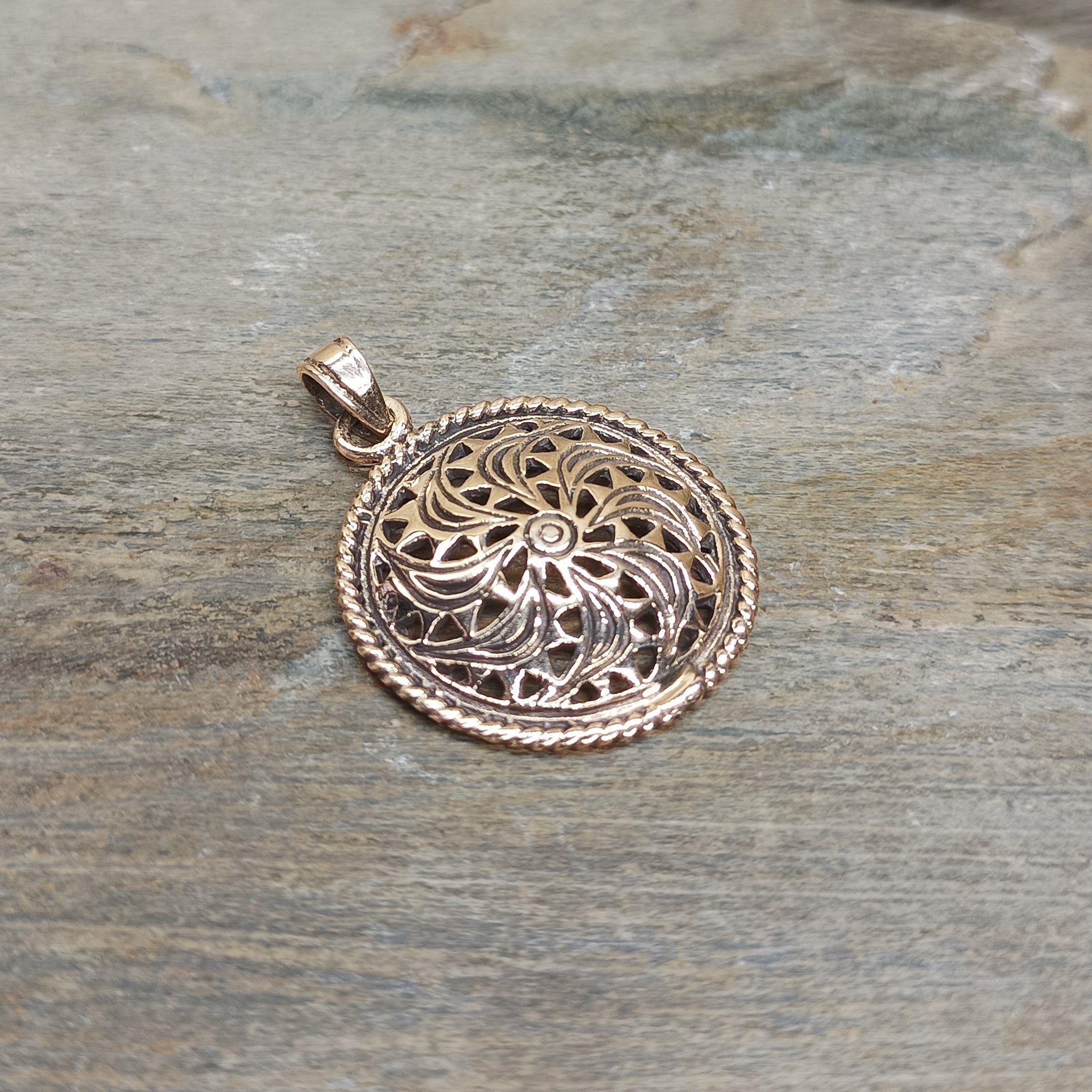 Bronze Sun Wheel Pendant on Stone