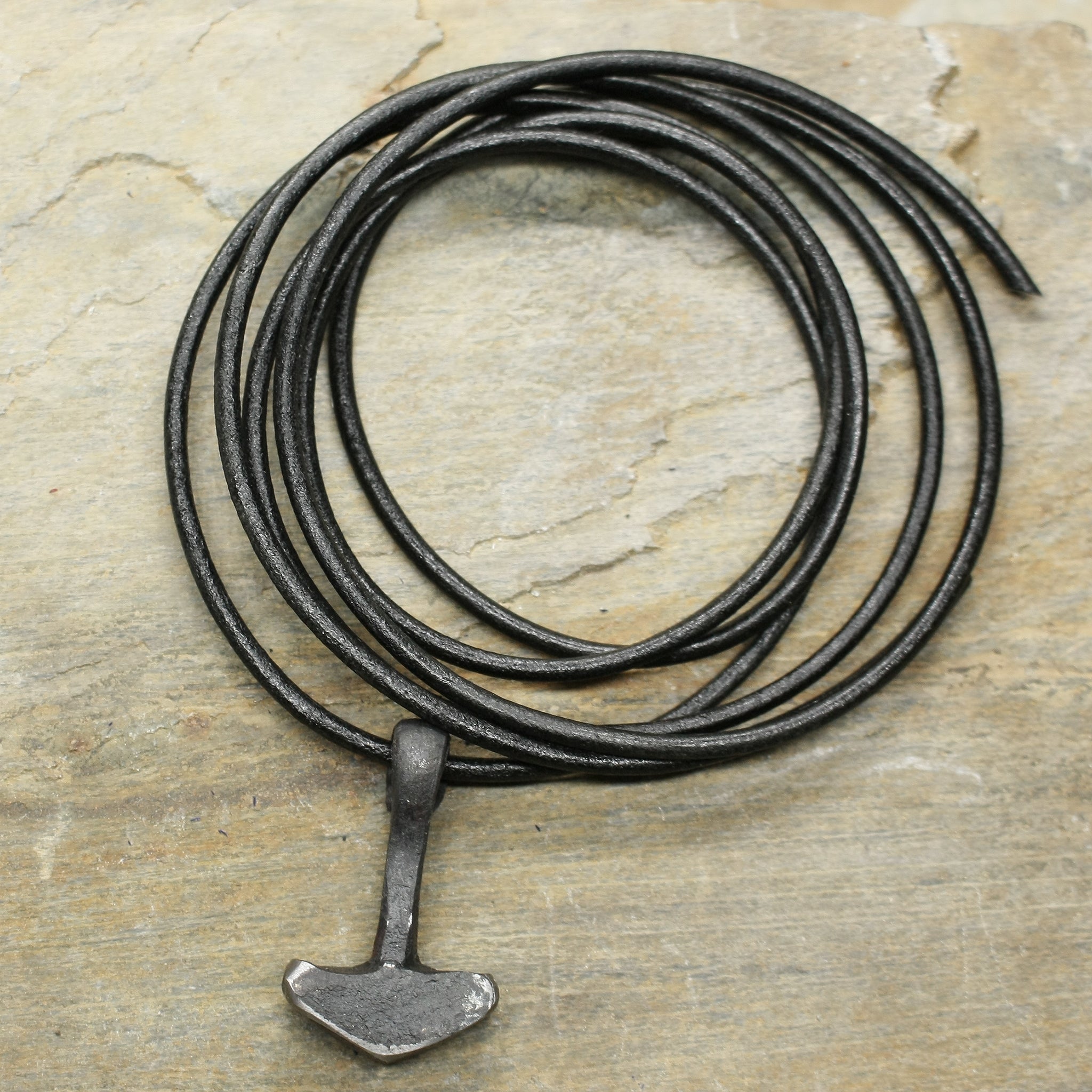 Hand Forged Replica Iron Thors Hammer Pendant on 2mm Black Thong on Rock