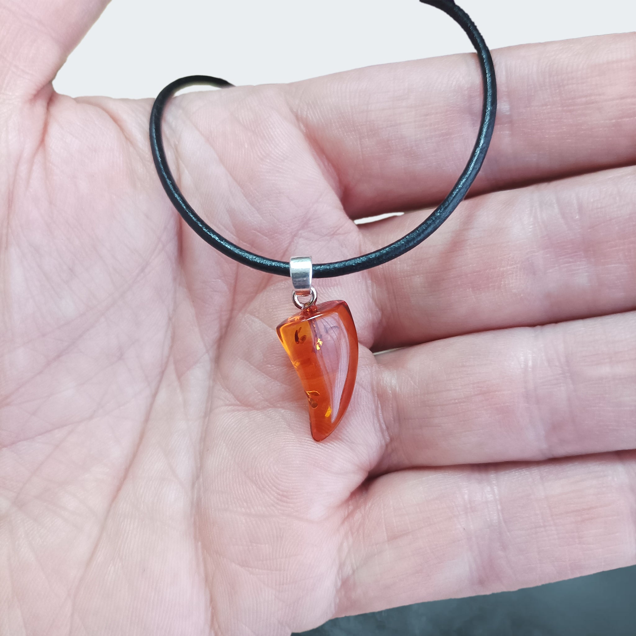 Hand-Cut &amp; Polished Amber Pendant, Shaped into a Wolf's / Dragon's Tooth with Sterling Silver Hanger on Leather Cord, on Hand