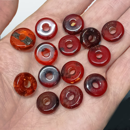 Polished Baltic Amber Beads with a Drilled Central Hole on Hand