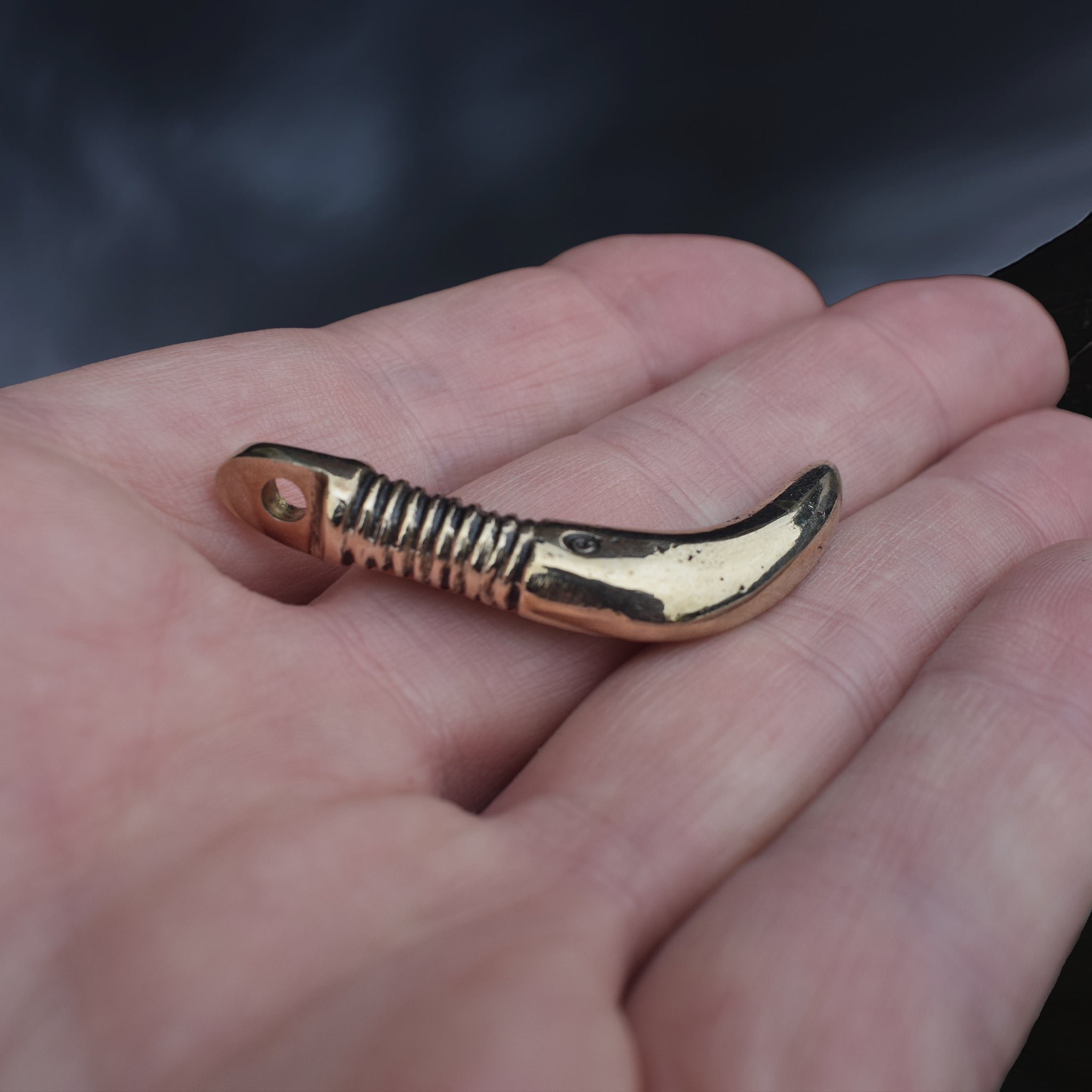 Solid Bronze Replica Viking Bear Tooth Pendant from 9th to 11th century Finland on Hand - Side Angle View