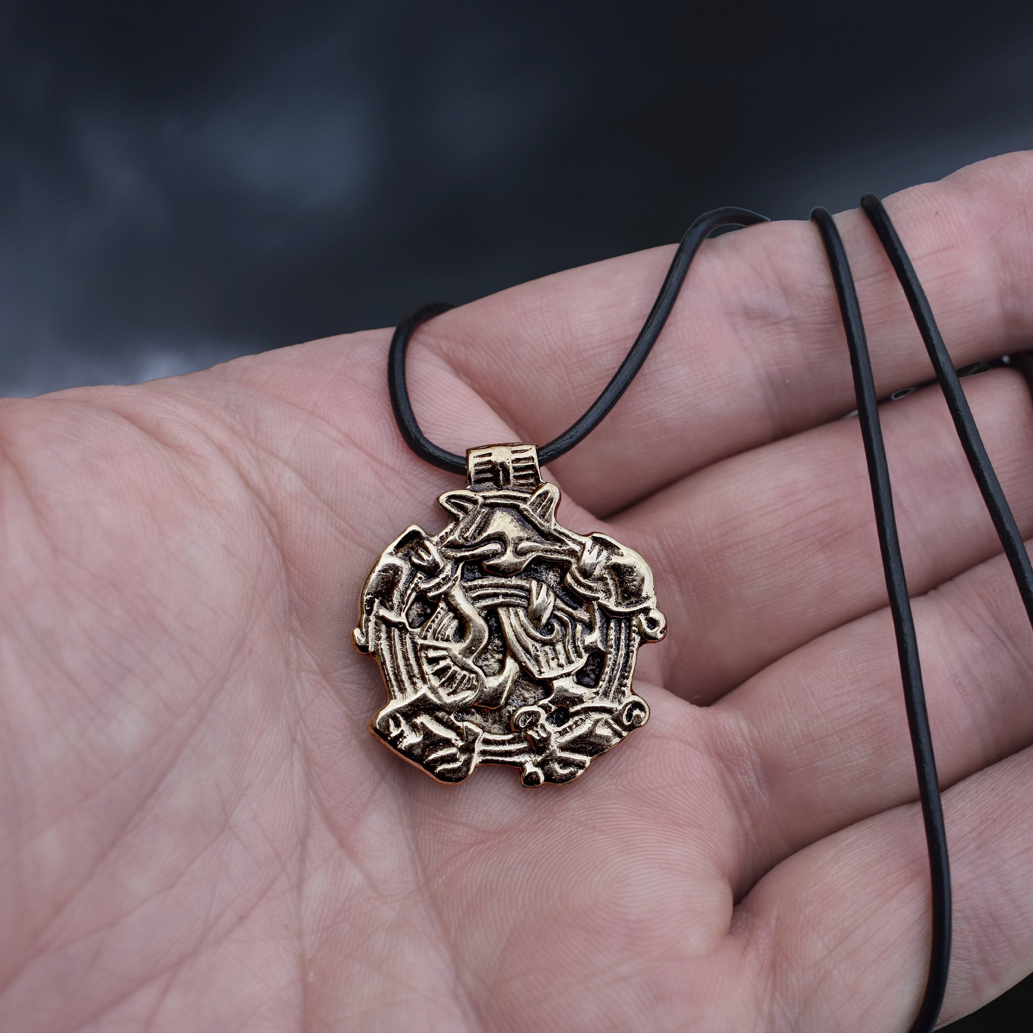 Solid Bronze Replica Viking Gripping Beats Pendant from&nbsp; 10th century Sweden on Leather Cord Wrapped Around Hand