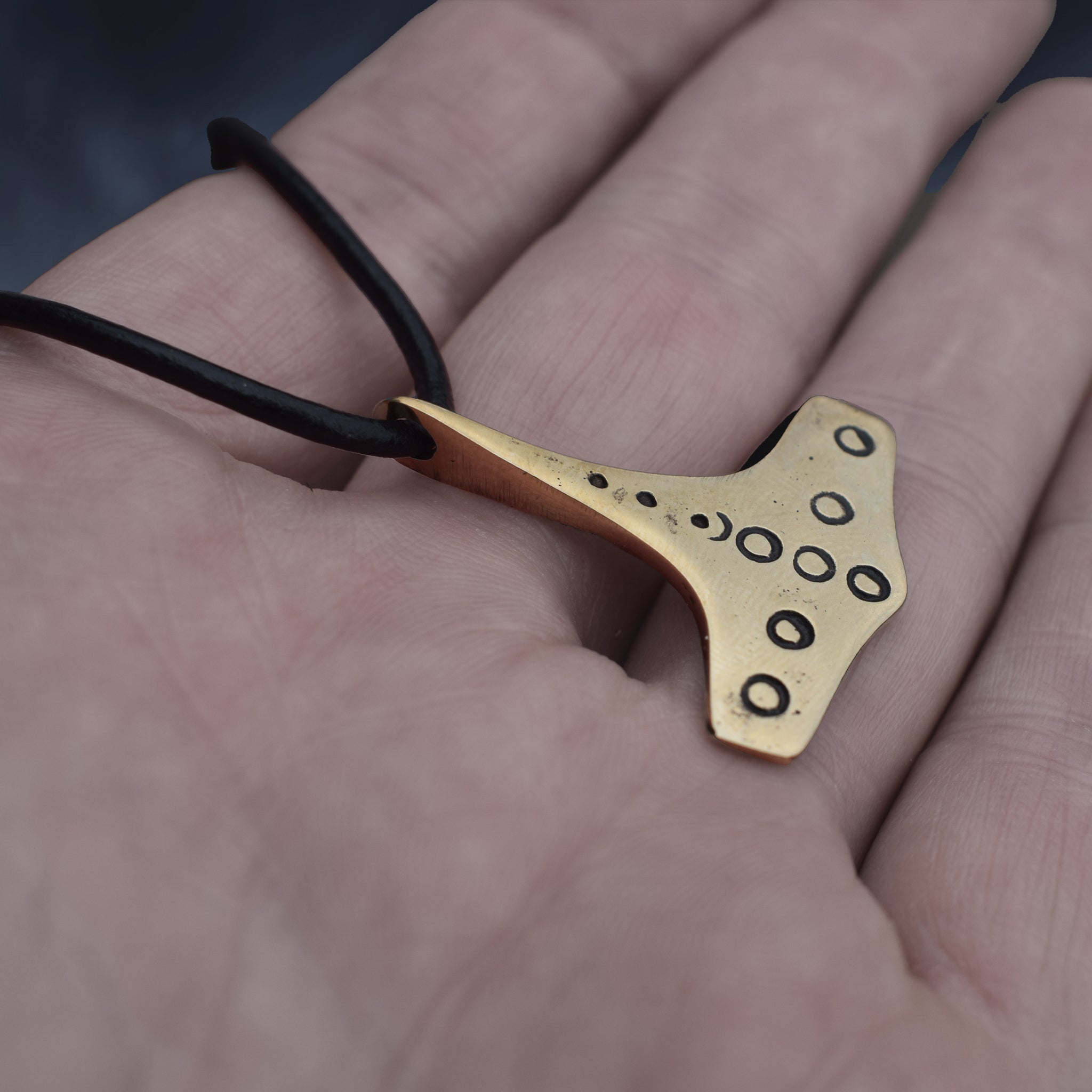Bronze Replica Thors Hammer Pendant from 10th Century Denmark with Dot & Ring Design on Leather Cord, on Hand - Side Angle View