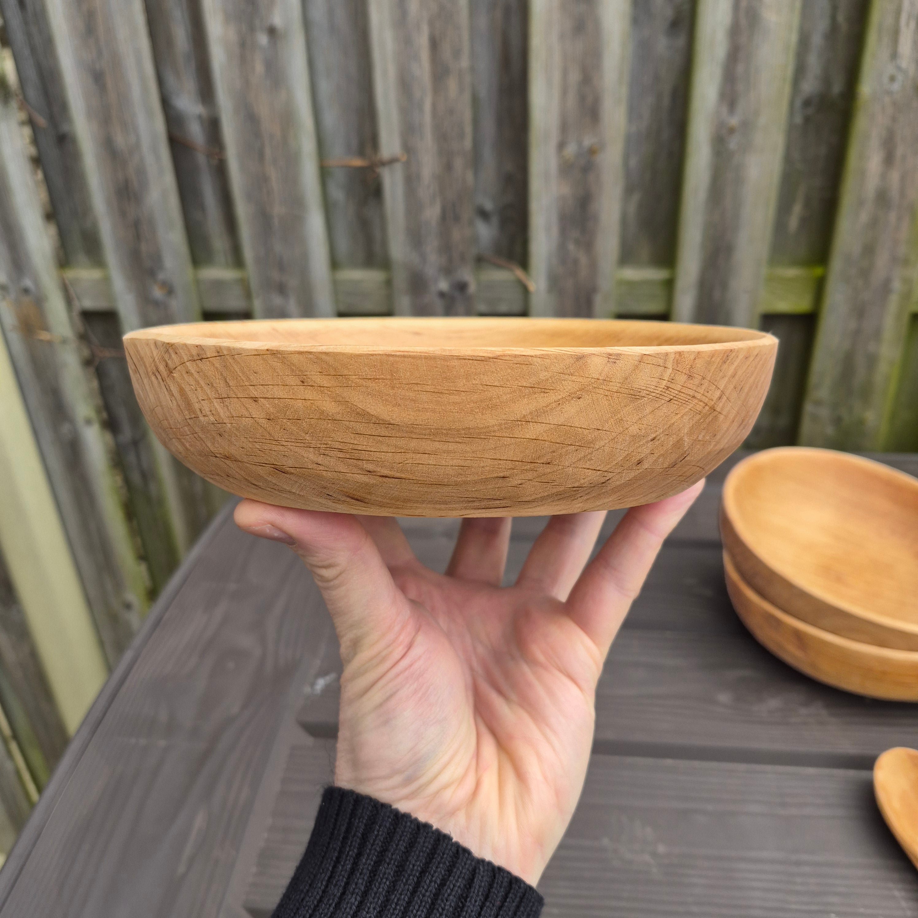 Viking Age Replica Hand Turned Alder Wood Bowl - Medium in Hand Held Aloft from The Viking Dragon