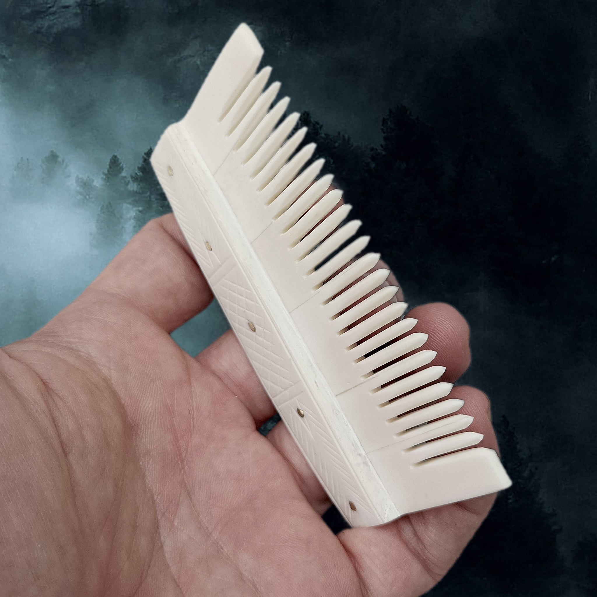Decorated Bone Viking Comb with Rivets in Hand - Side Angle View