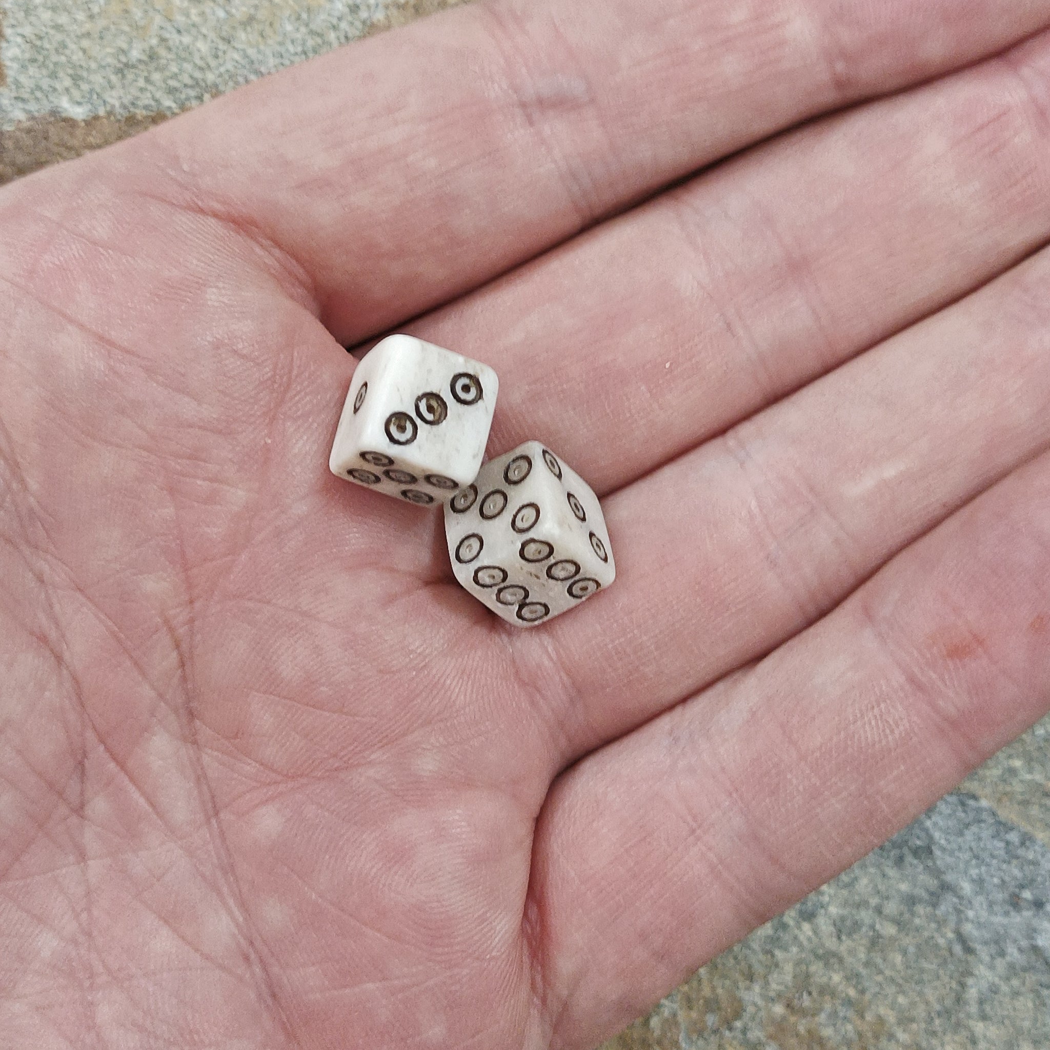 Small Natural Bone Replica Viking Dice with Black Dot and Ring Incised Spots in Hand x 2