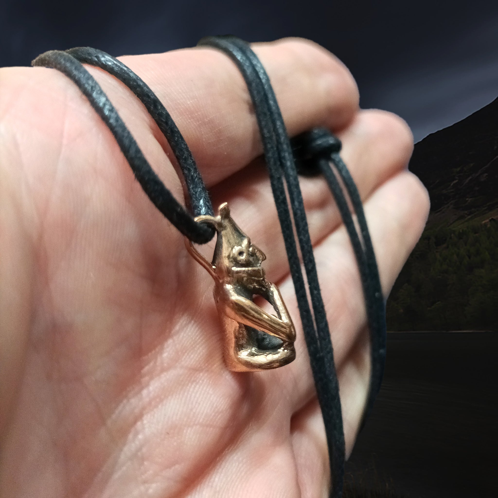 The Norse Fertility God, Frey - Cast as a Bronze Viking Pendant on Black Cord on Hand - Side View