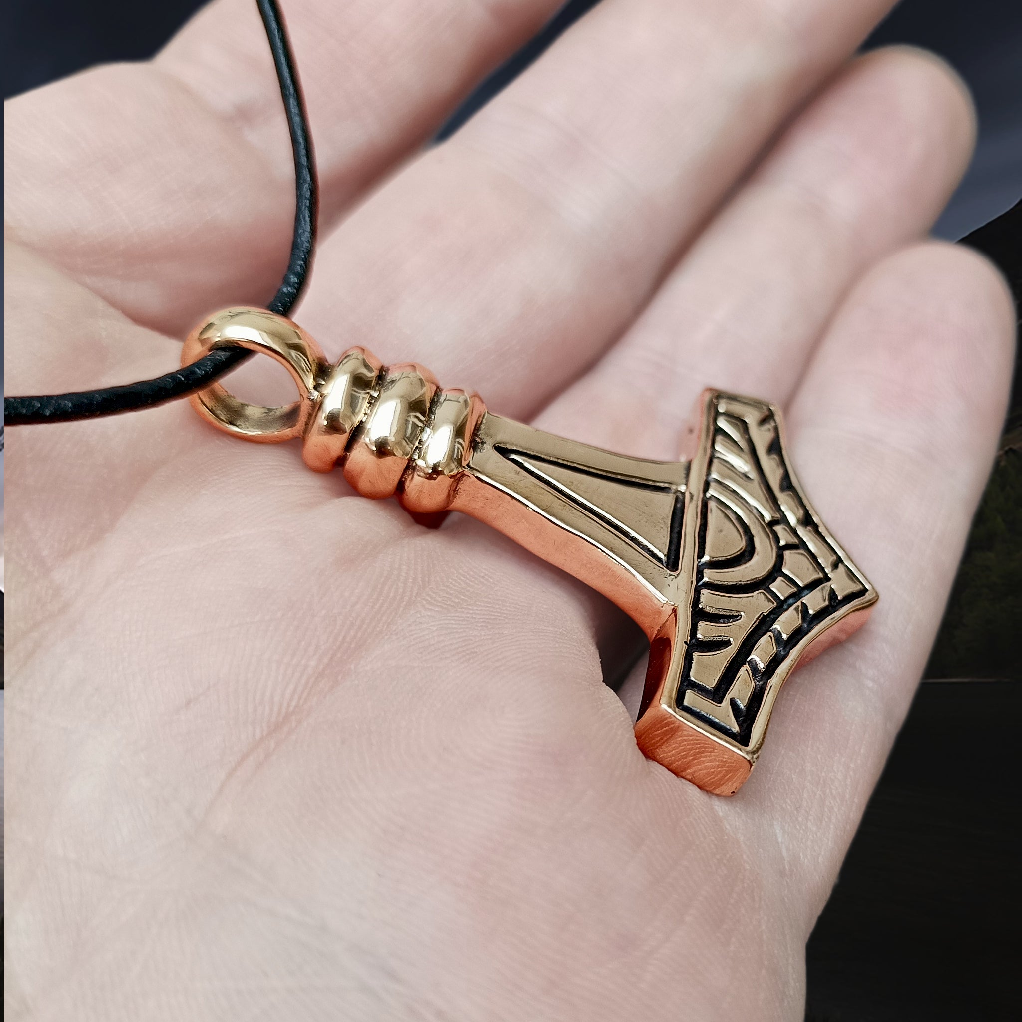 Large Bronze Gotland Replica Thors Hammer Pendant on Hand on Leather Thong - Side Angle View