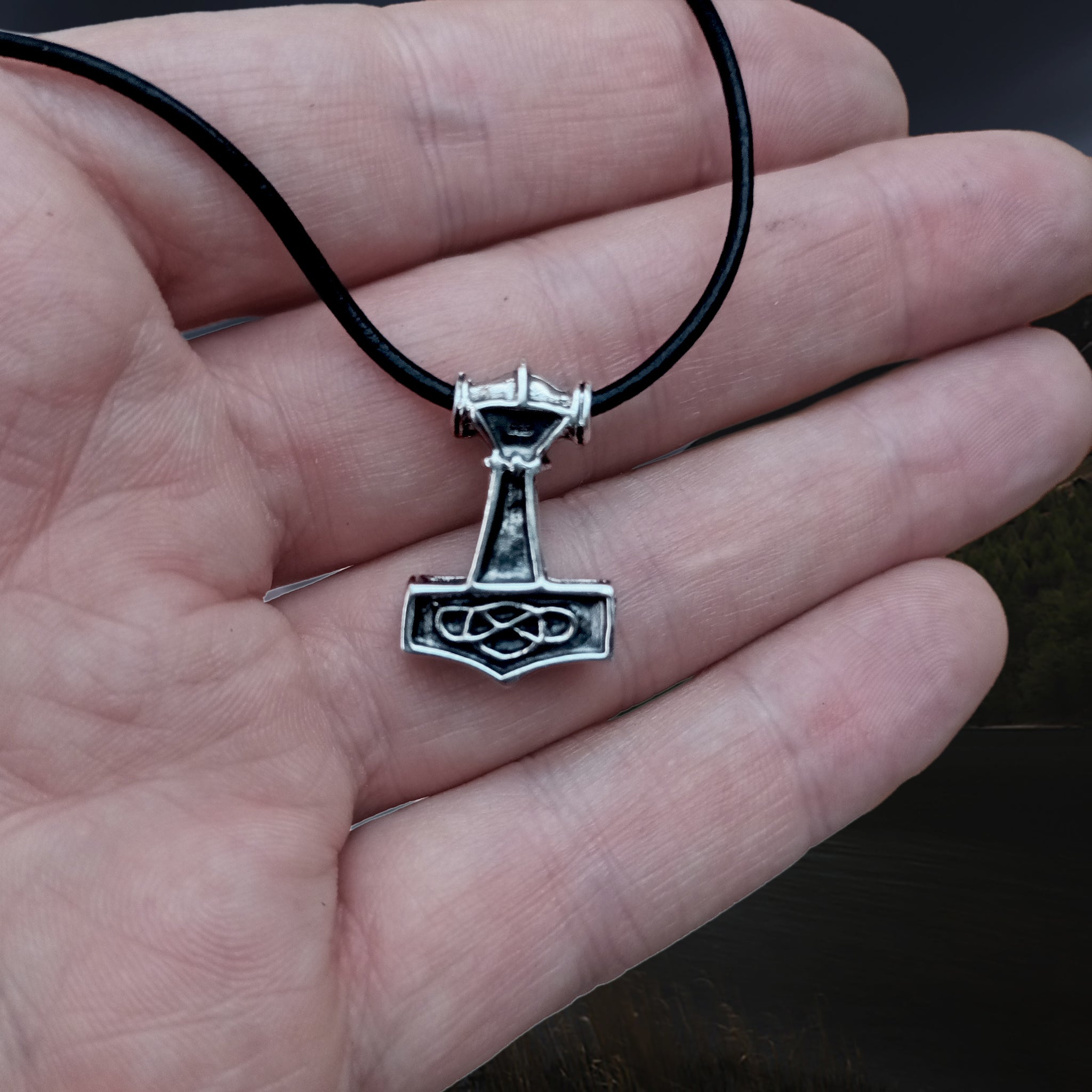 Small Silver Thunder Thors Hammer Viking Pendant on Leather Thong on Hand - Back View
