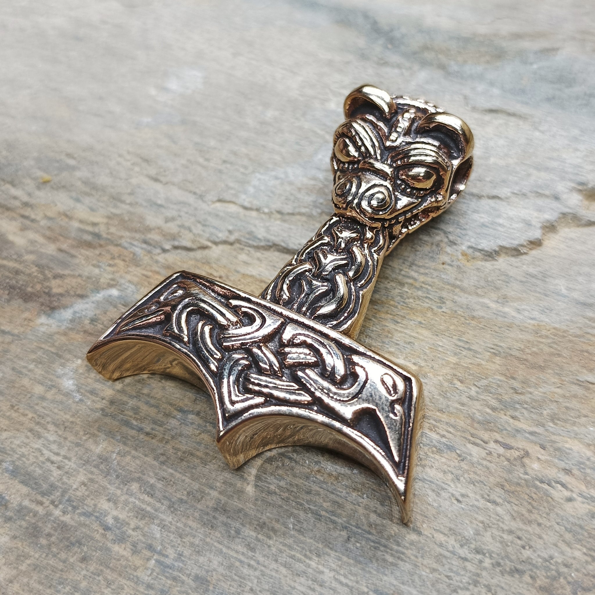 Bronze Large And Ferocious Thors Hammer Pendant on Rock - Angle View