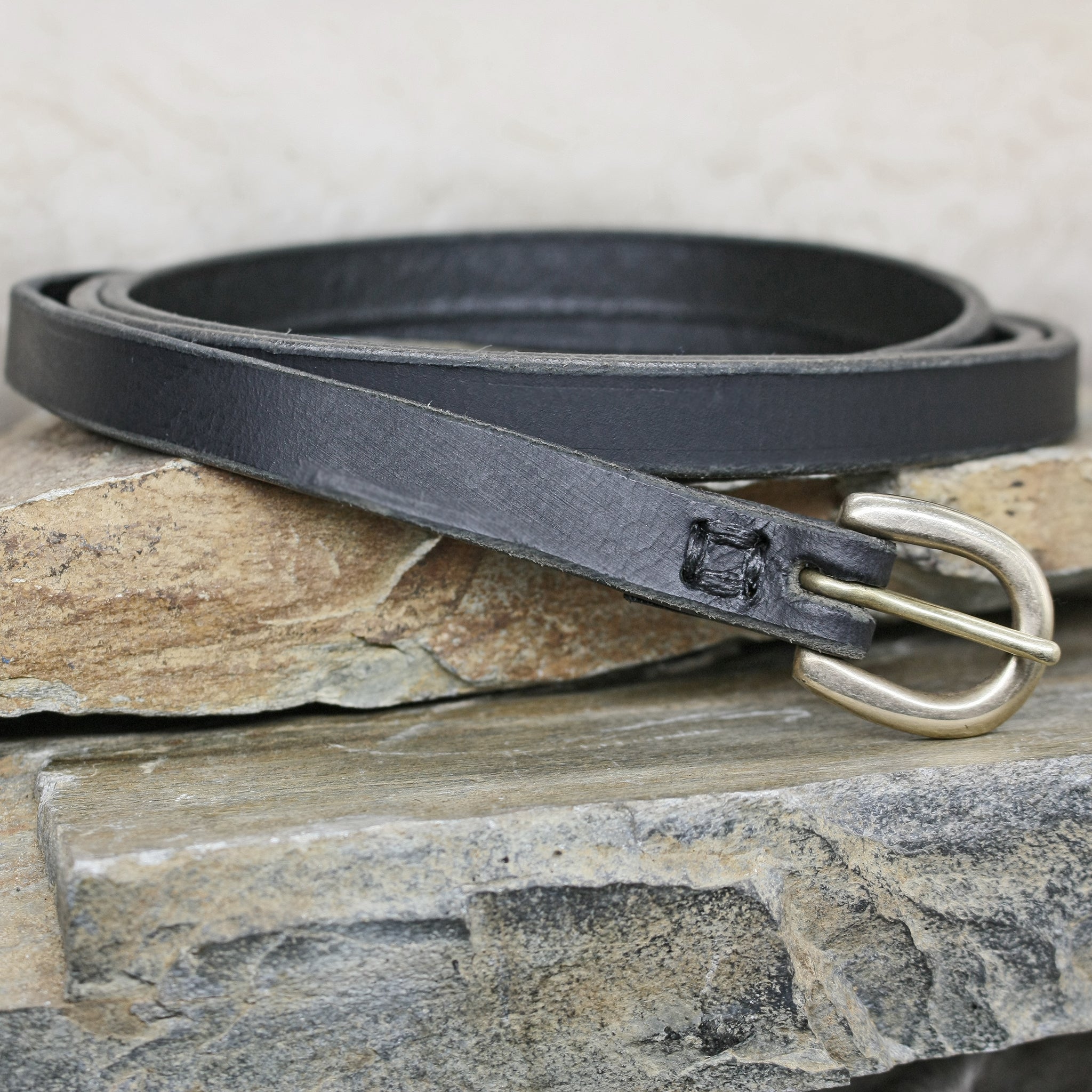 Black 12mm Wide Leather Viking Belt with Brass Buckle on Rock