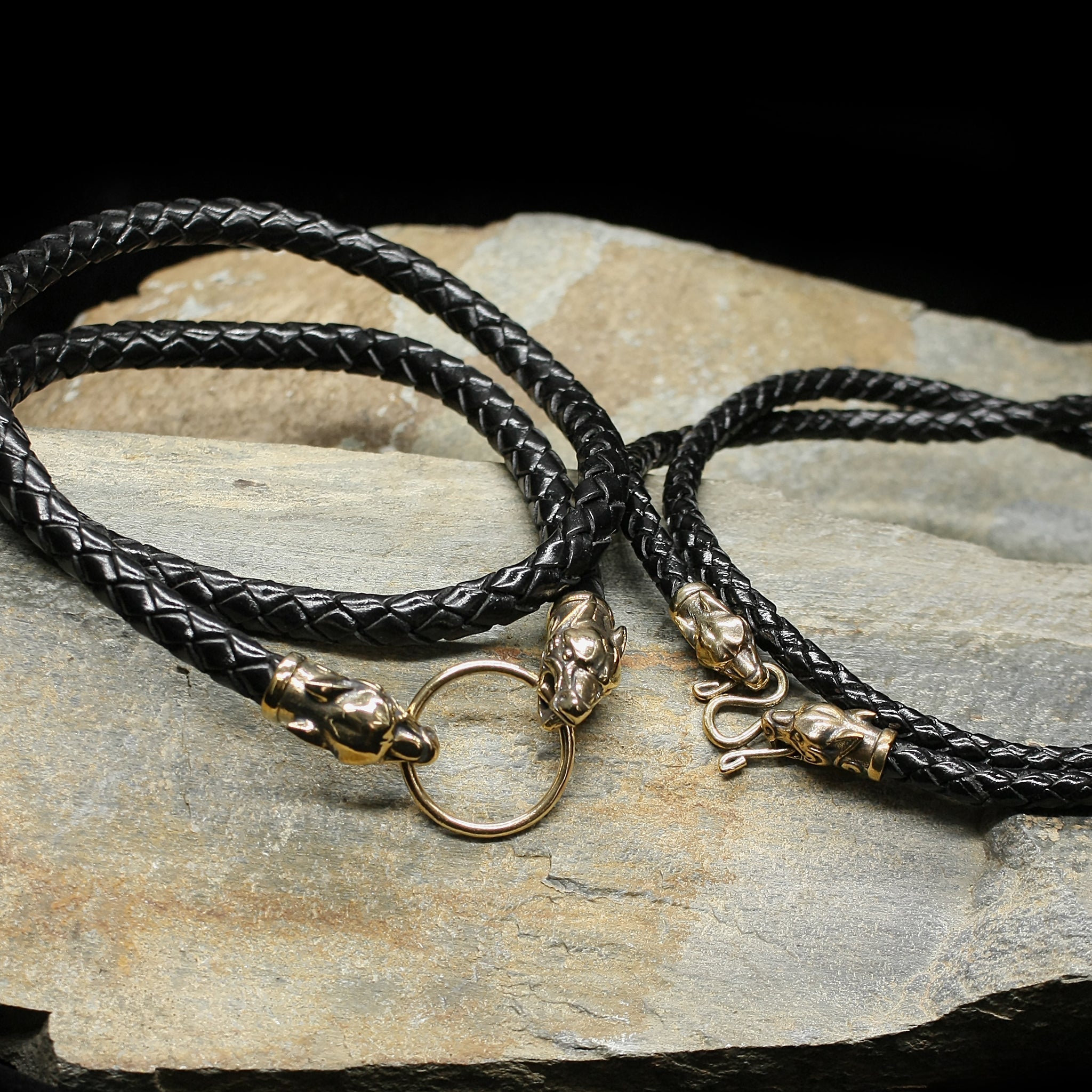 Braided Leather Necklace with Bronze Ferocious Wolf Heads on Rock