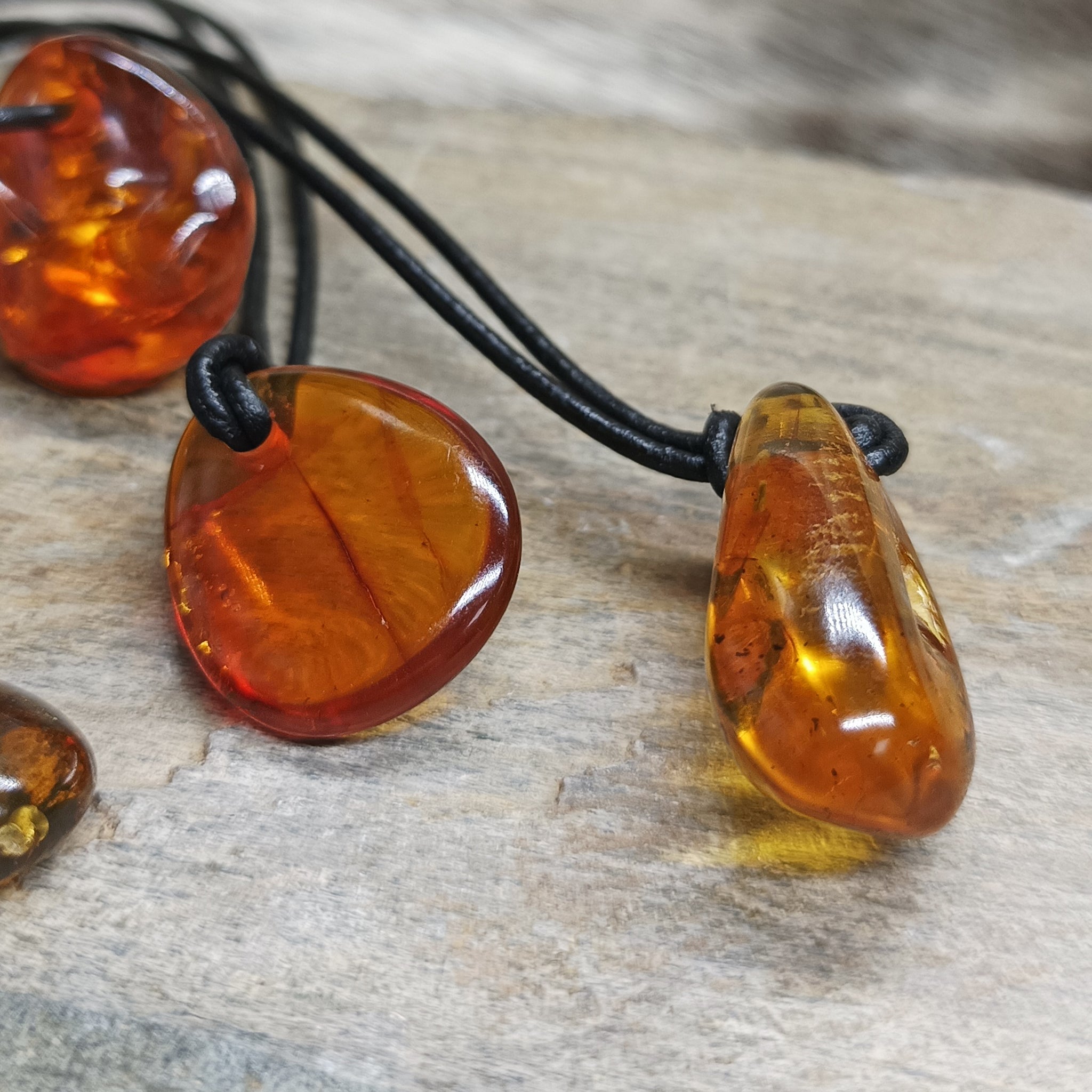 Amber Amulet Pendants on Rock - Side View