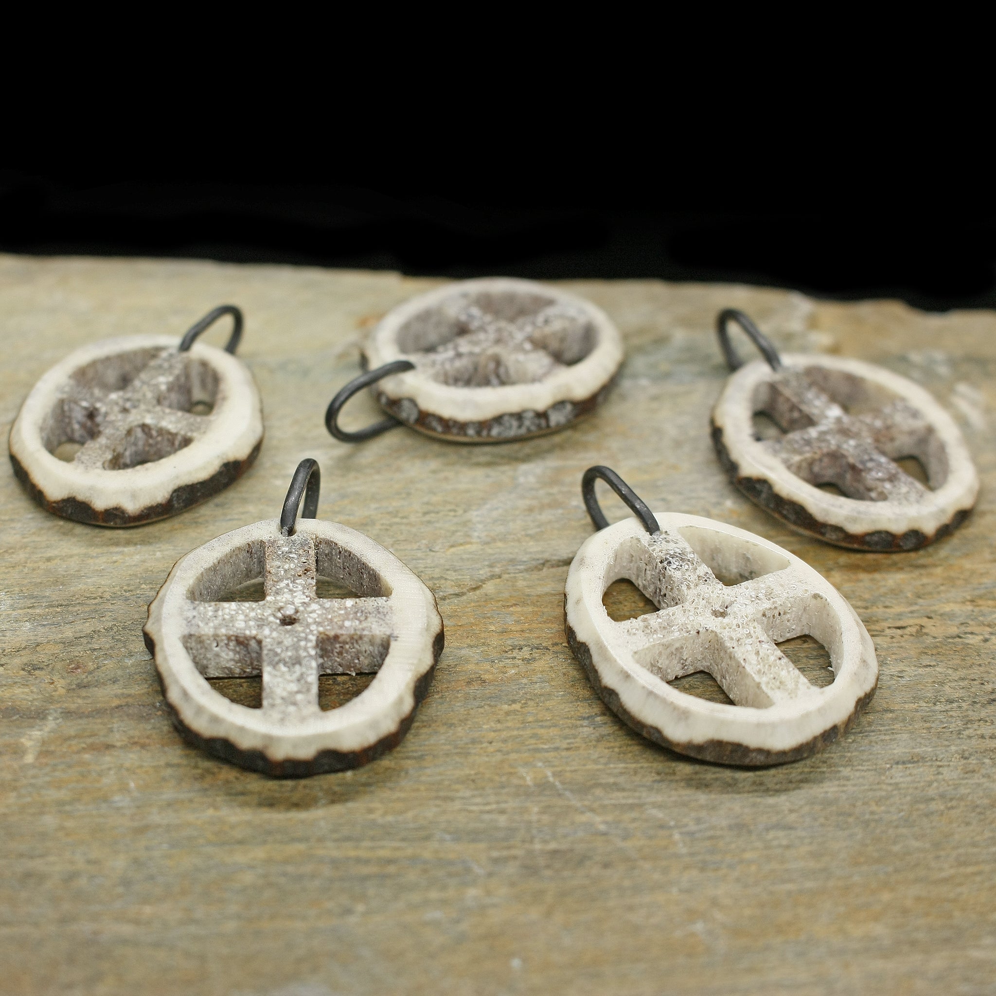 Antler Sun Cross Odin Pendants on Rock - Side Angle