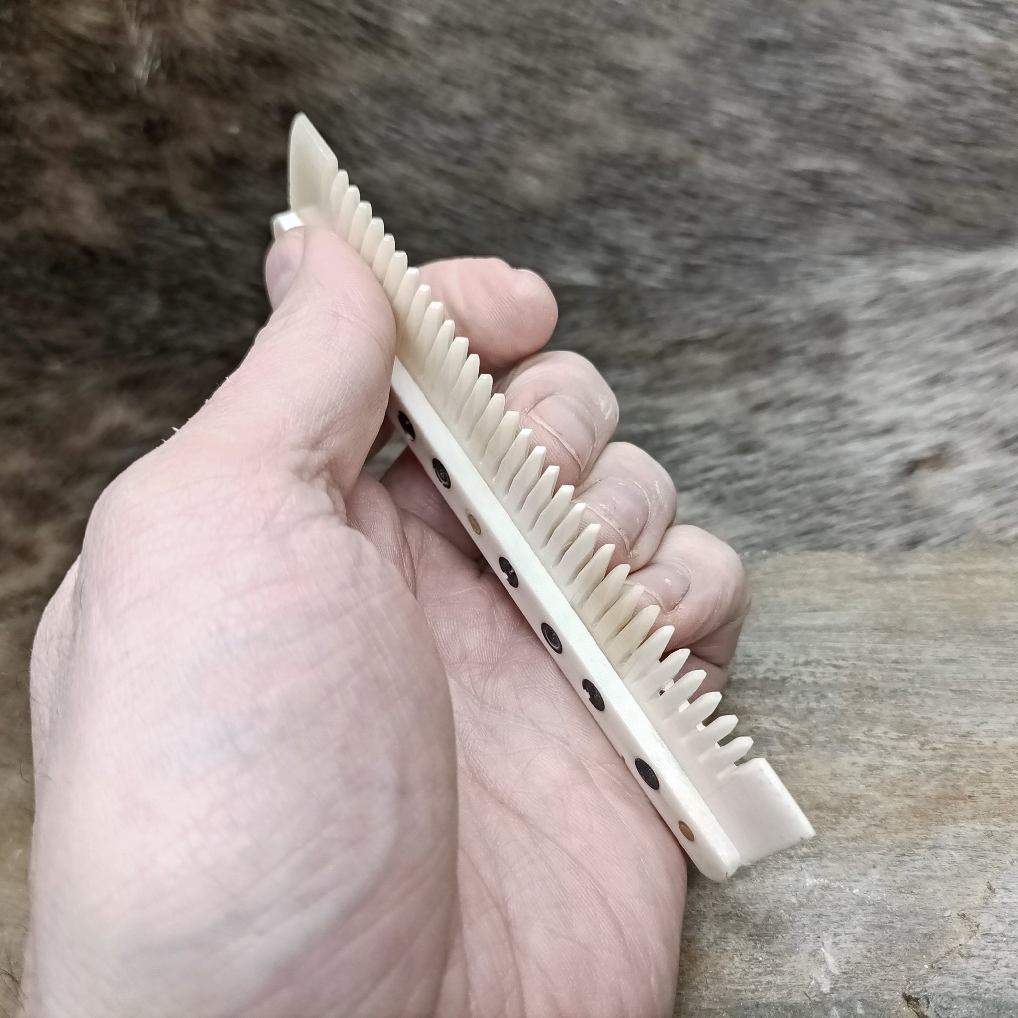 Medium Decorated Bone Viking Comb in Hand - Side View