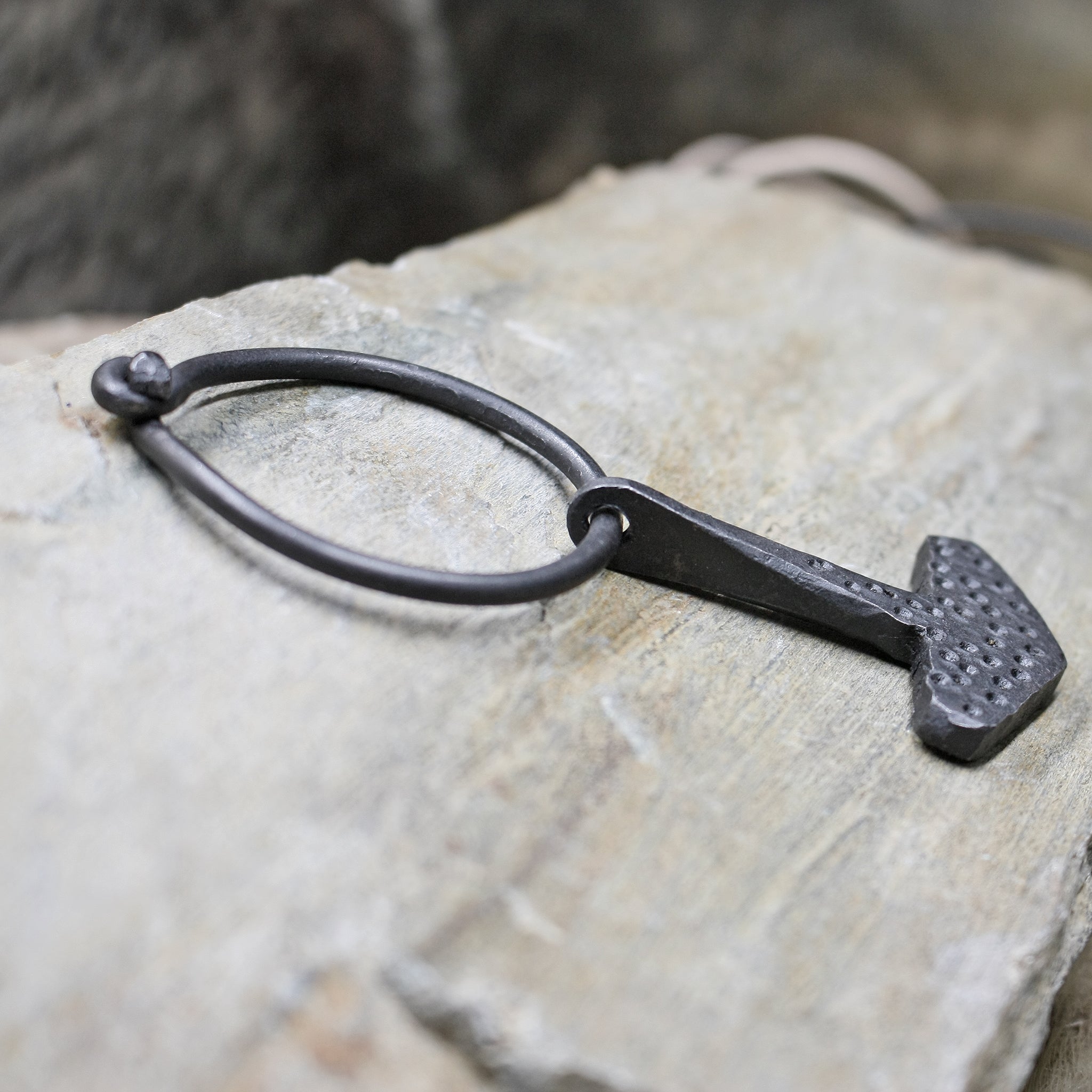 Embossed Iron Thors Hammer Replica Pendant on Ring on Rock - Side View