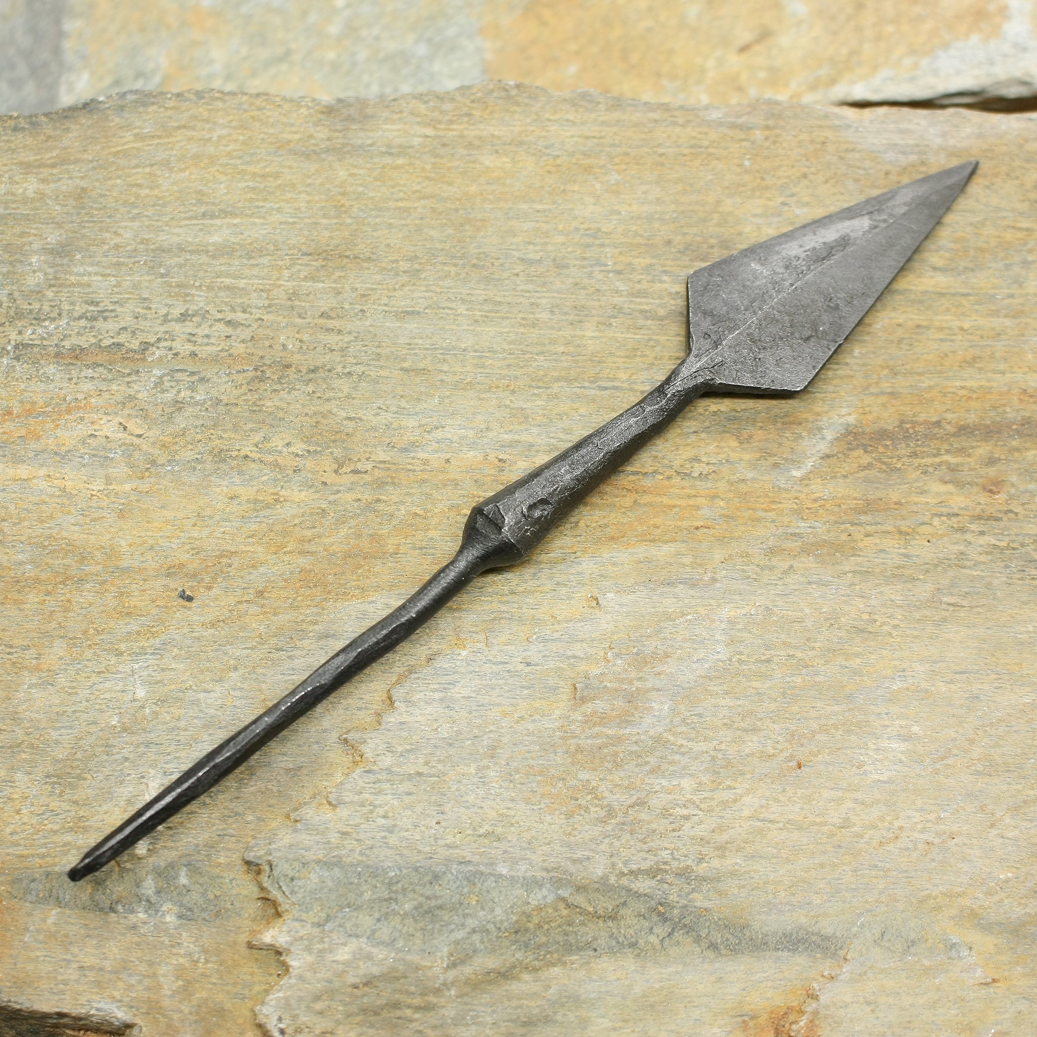 Hand-Forged Iron Arrowhead with Tang on Rock