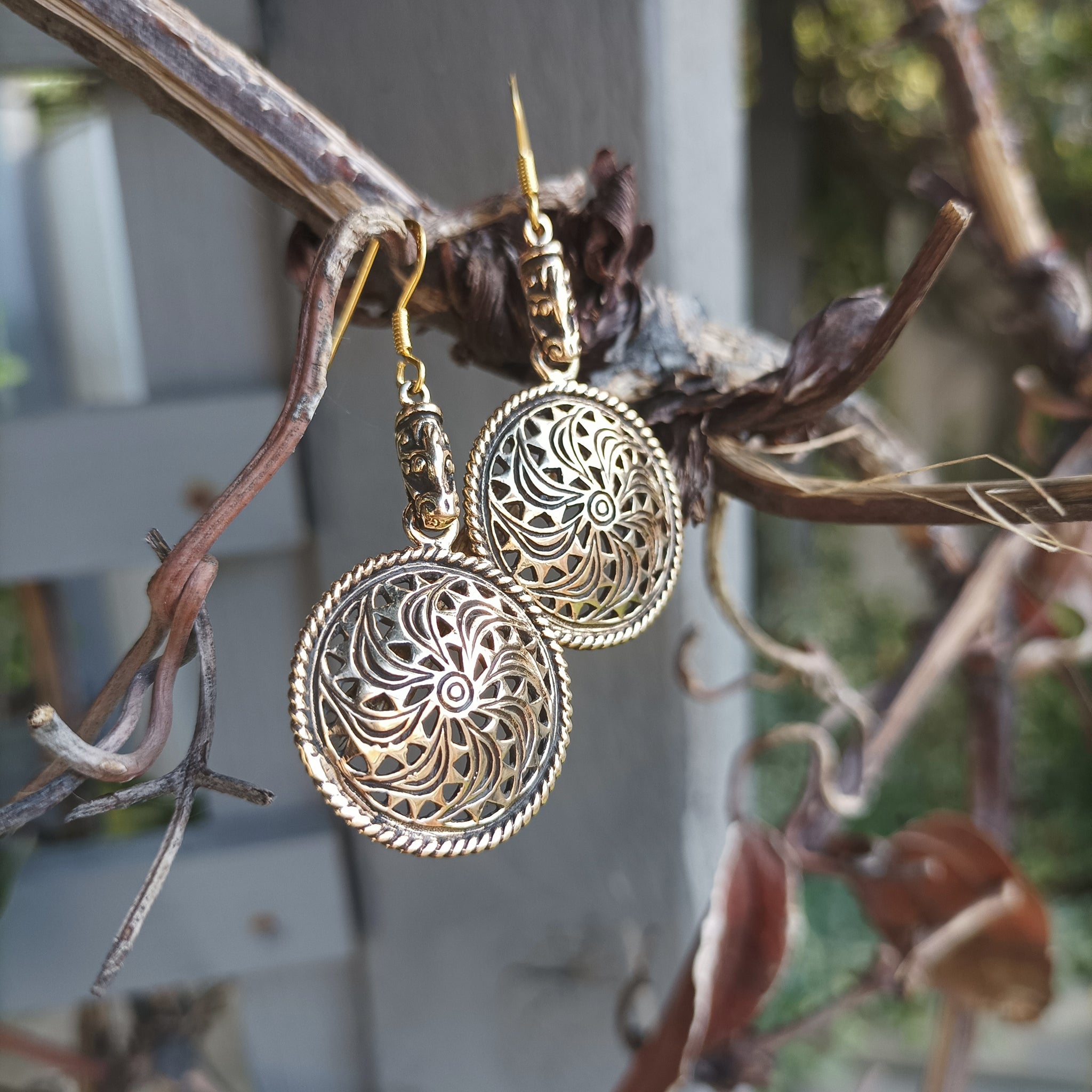 Bronze Gotland Sun Wheel Earrings Hanging in Tree - Angle View