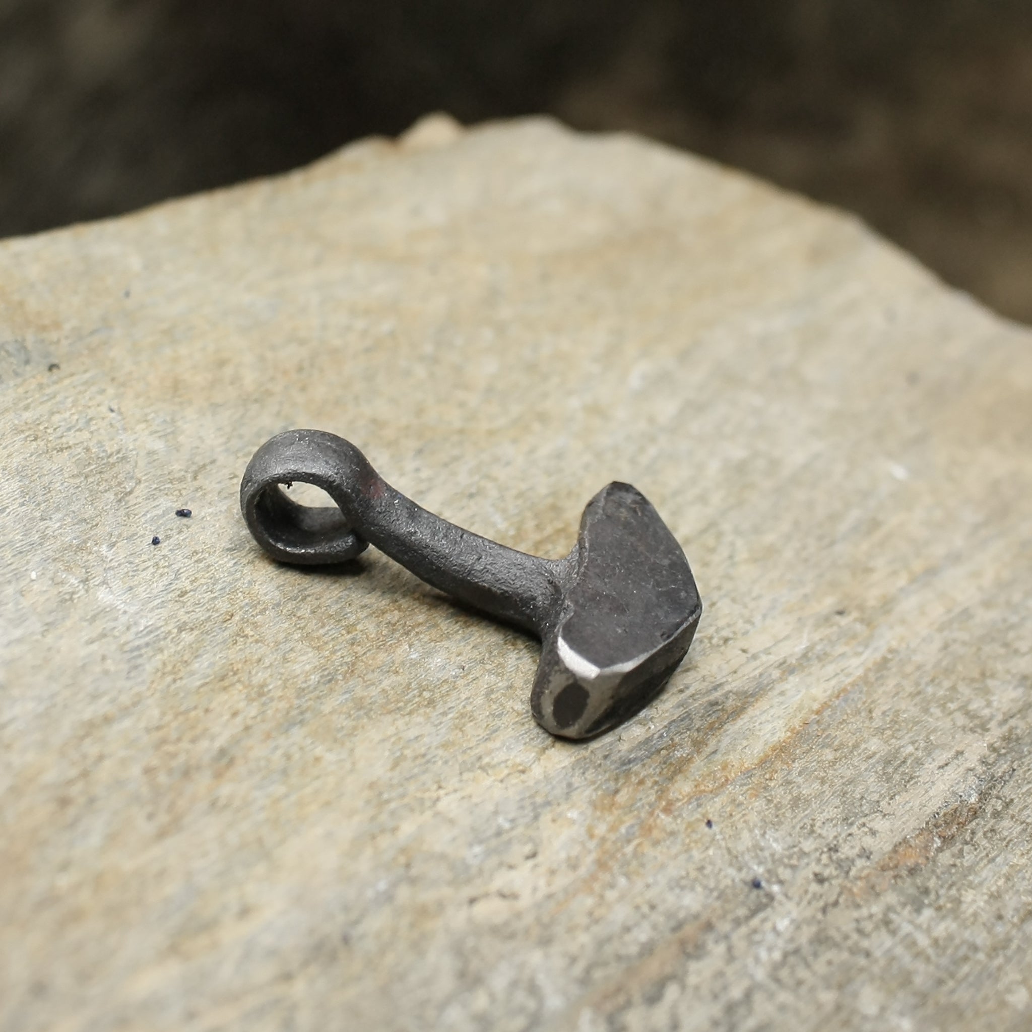 Hand Forged Replica Iron Thors Hammer Pendant on Rock - Side View