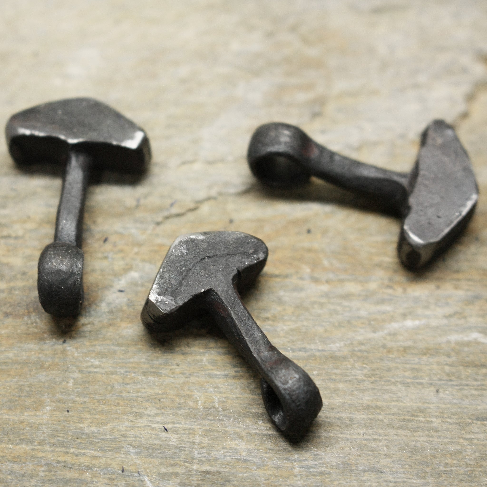 Hand Forged Replica Iron Thors Hammer Pendants on Rock